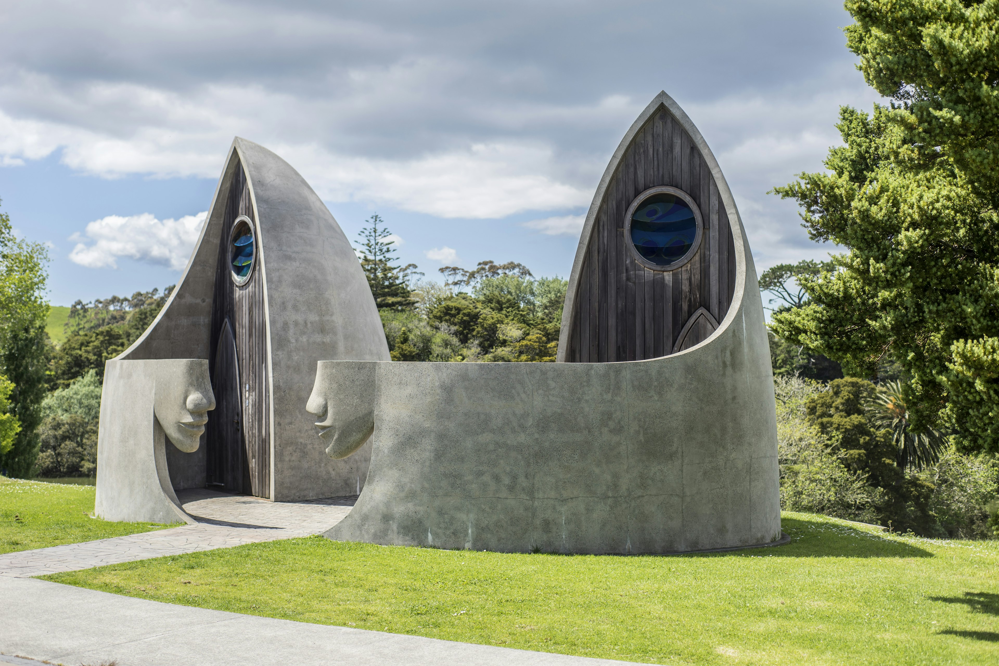 An image of two unique restrooms, the entrance containing a carved lower half of a face made from stone that wraps around the back.