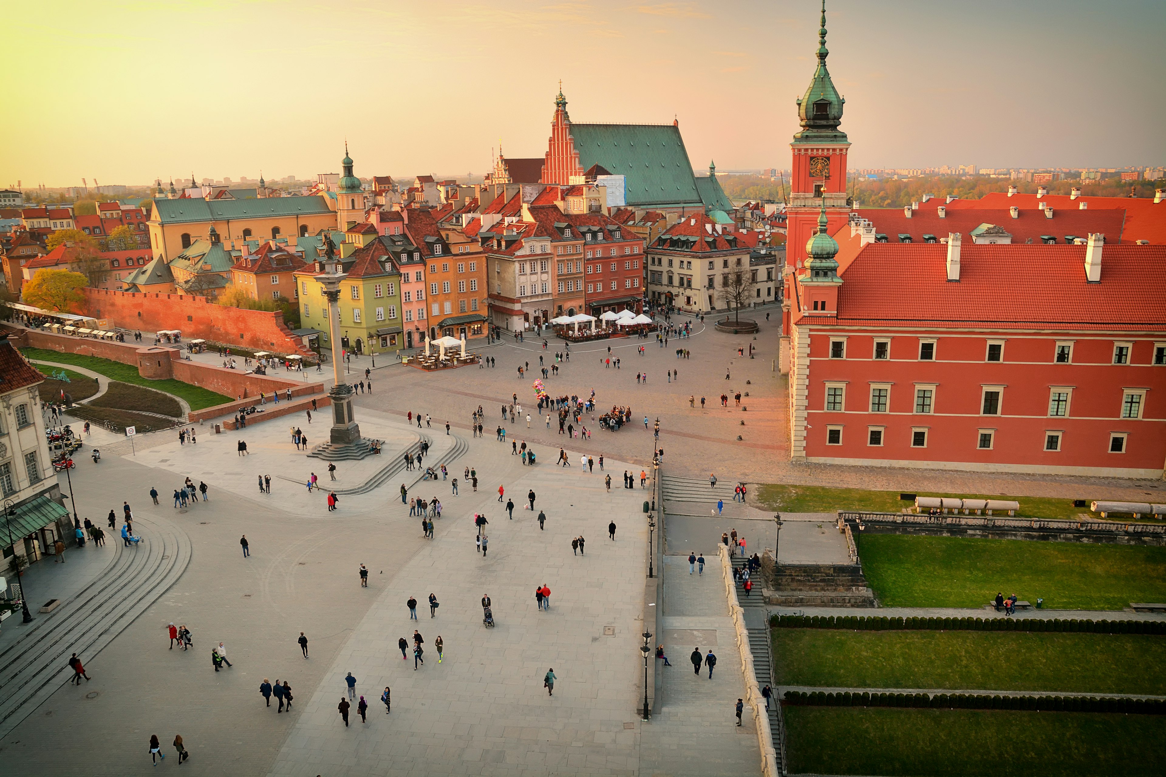 Elevated view of town square, Warsaw. Many people walking through a courtyard during the late afternoon.