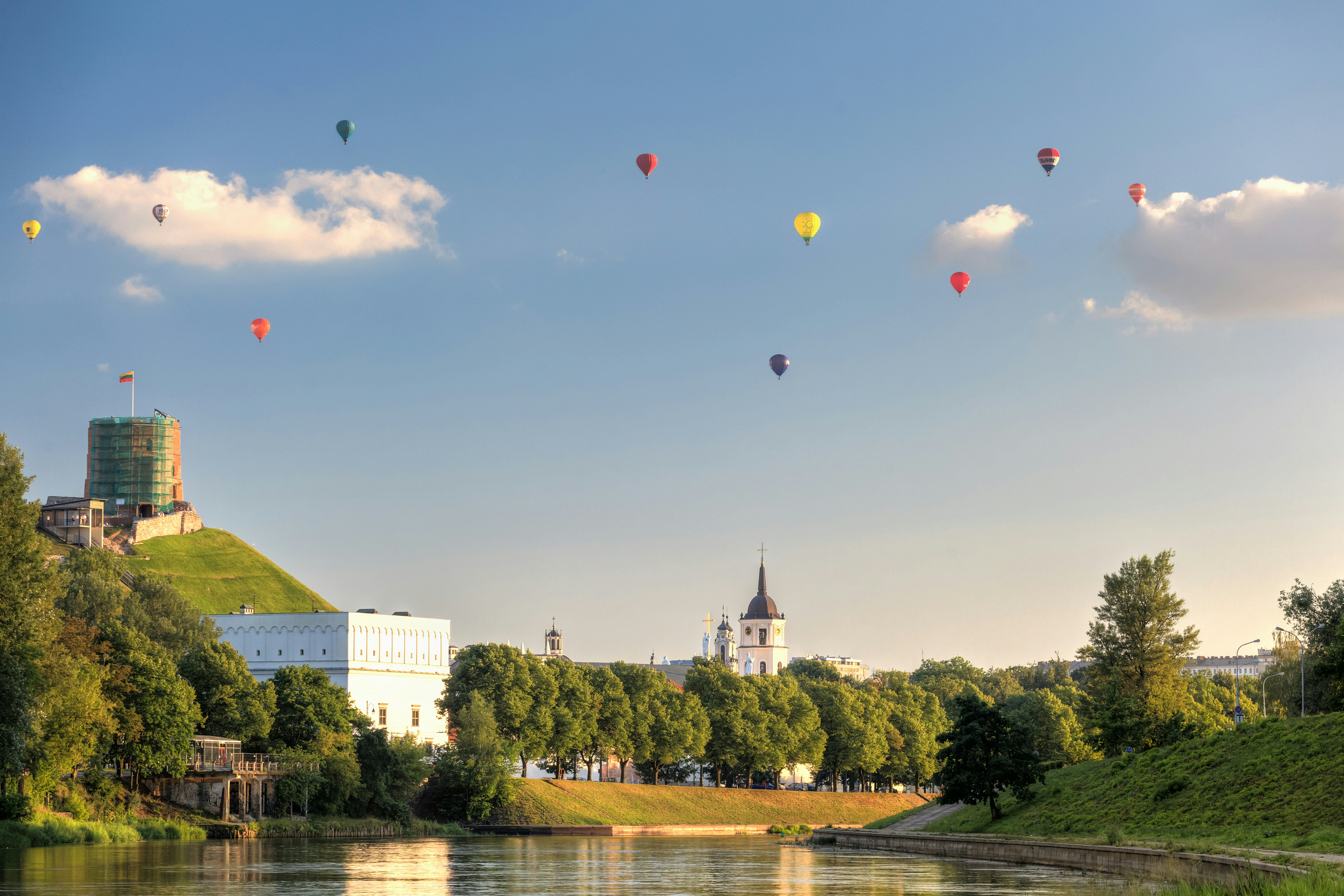 Bunch of hot air balloons in the air, giving a unique view of the city.