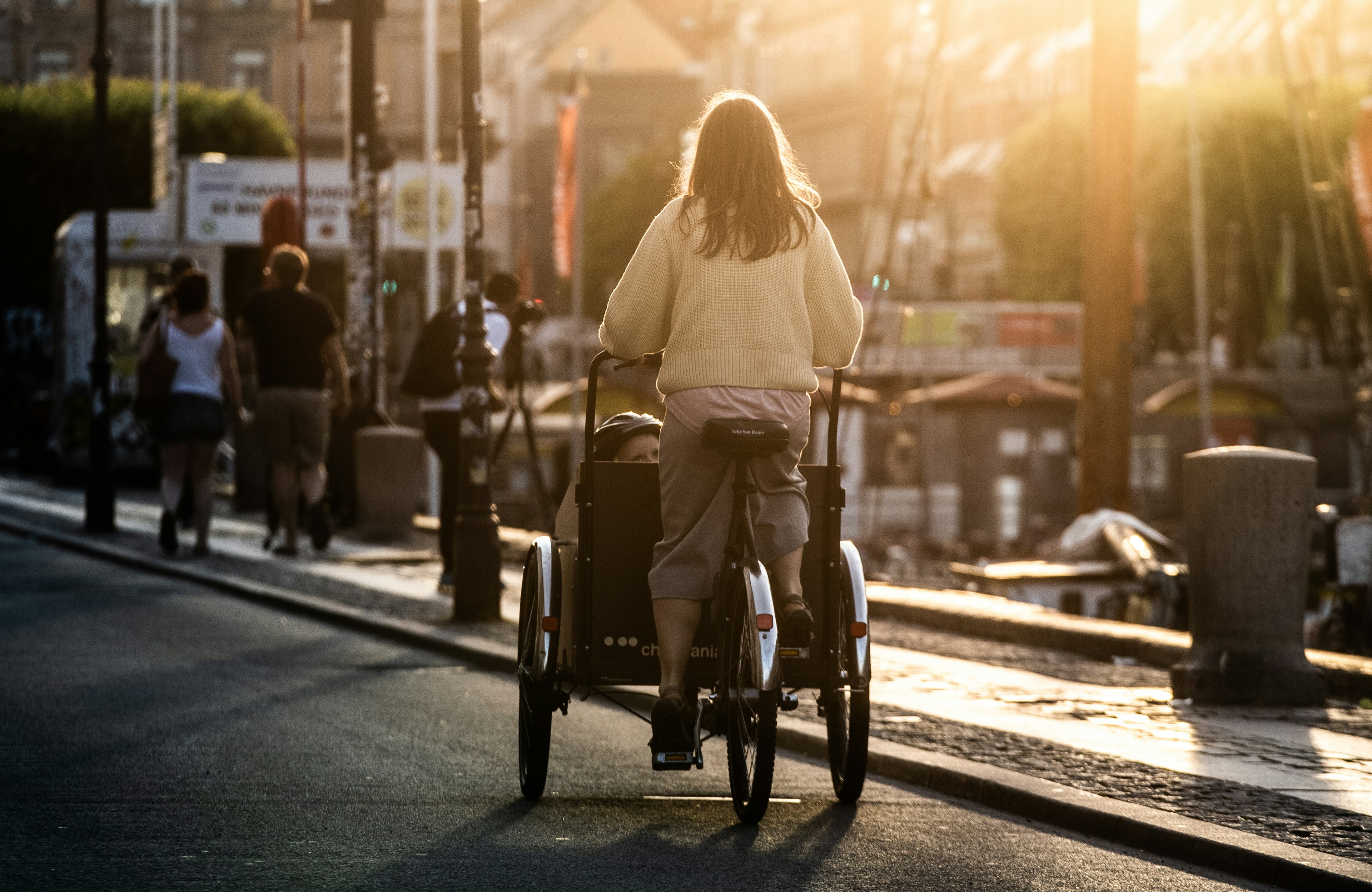 A woman riding a cargo bike in Nyhavn, Copenhagen.