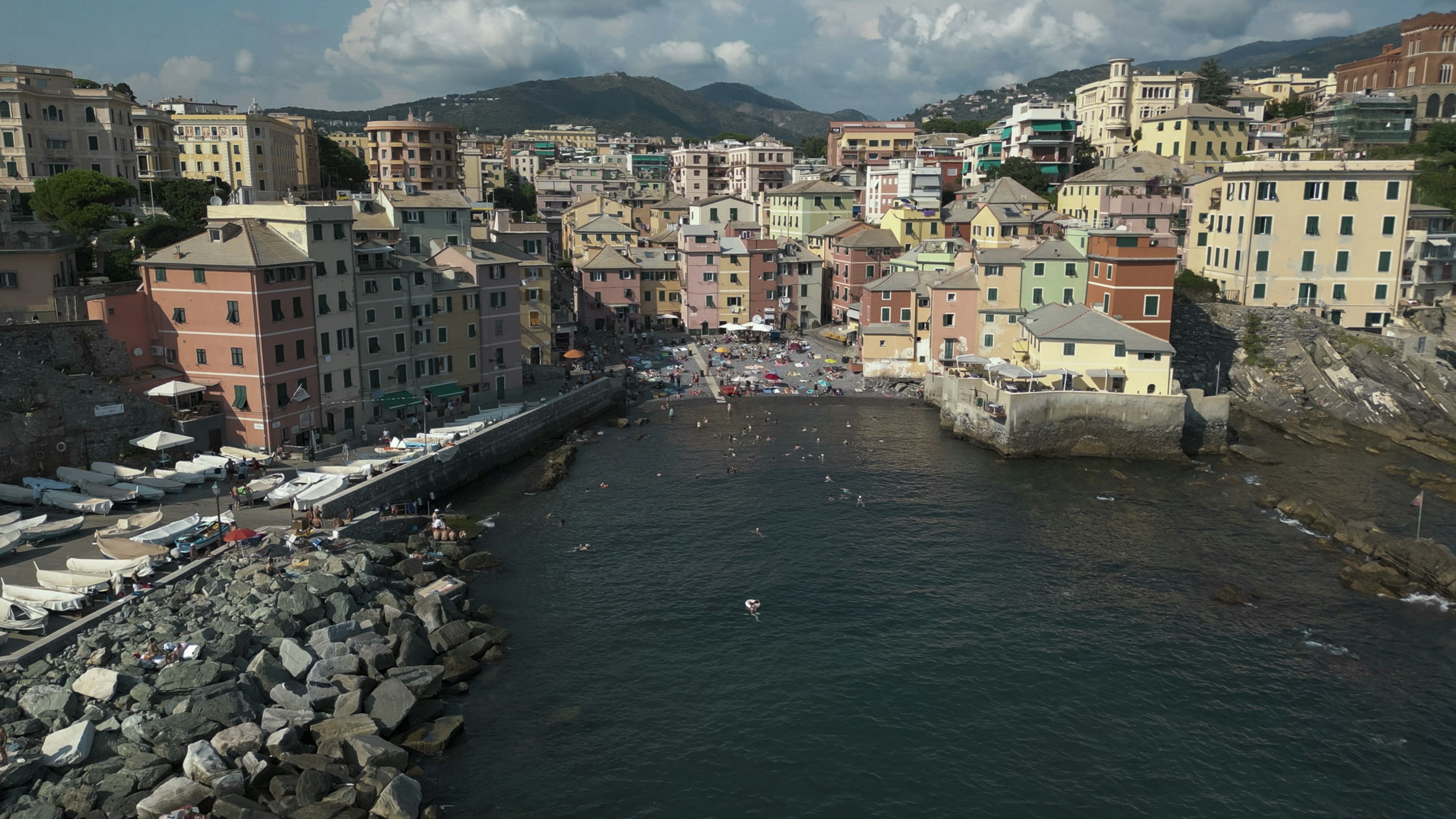 A drone photo of colored buildings along the shore in Boccadasse with sea view, Genoa, Liguria, Italy