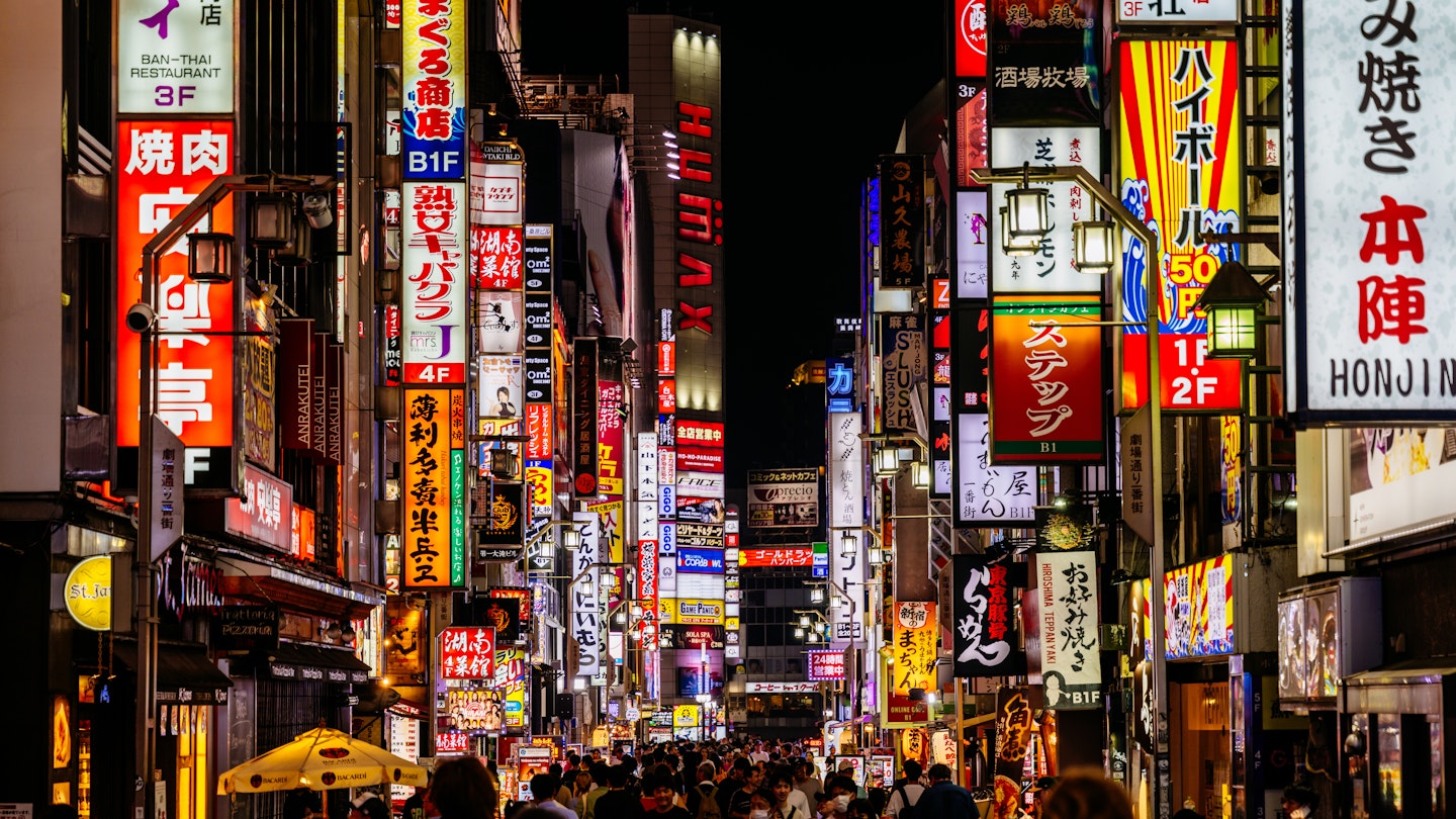 A Tokyo street at night lined with neon lights