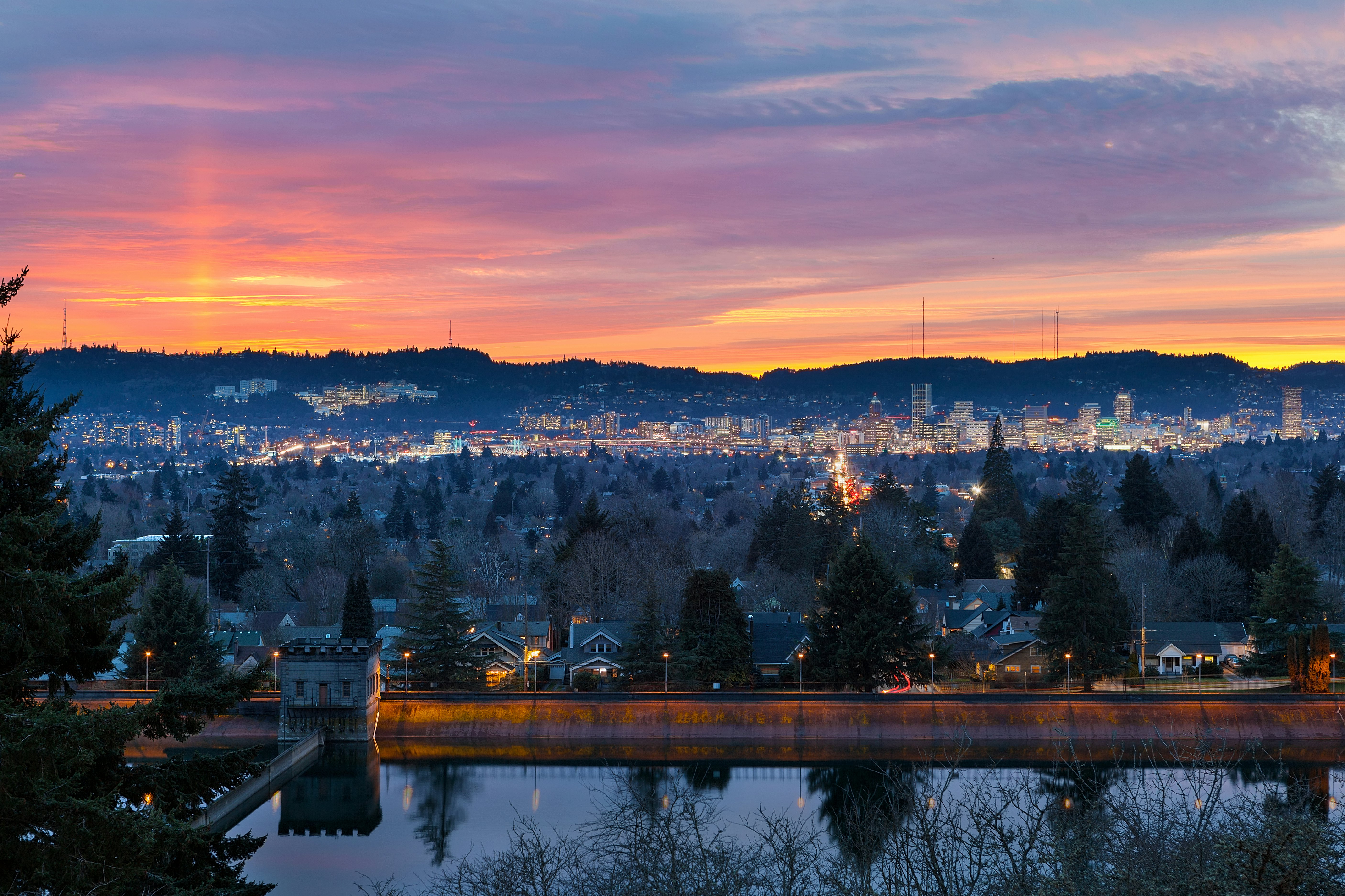 A colorful sunset from the top of Mt Tabor, overlooking Mt Tabor City Park Reservoir and the skyline of downtown in the distance, Portland, Oregon, USA