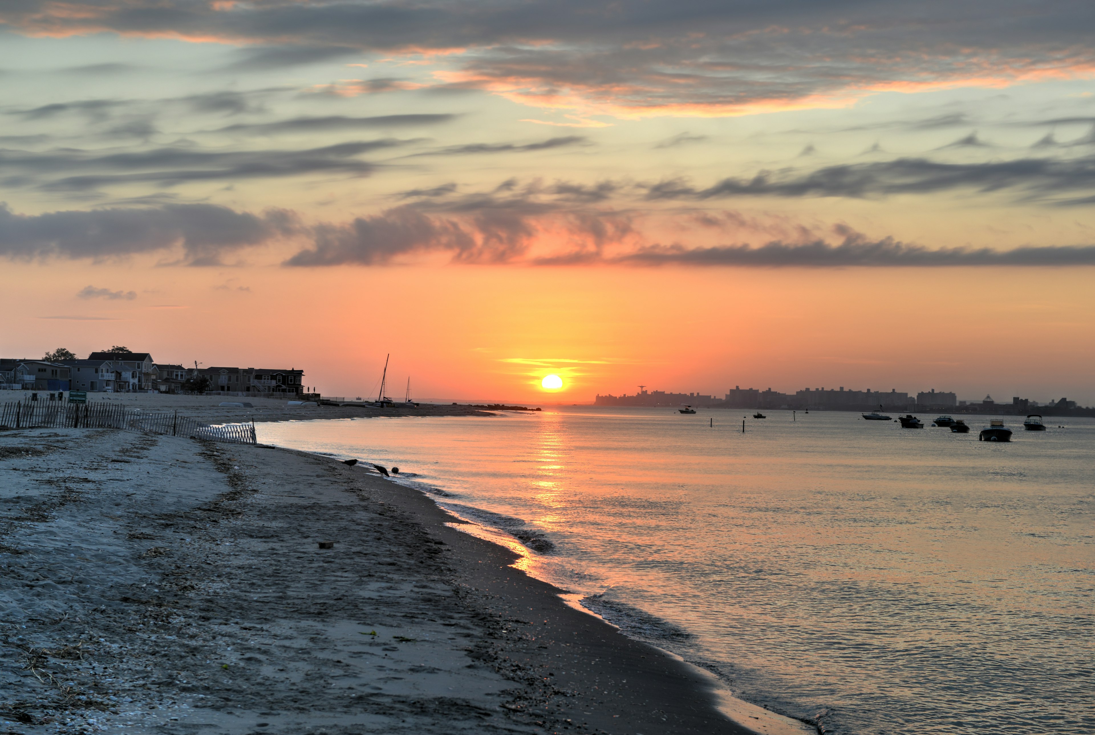 An empty beach as the sun sets casting an orange glow across the sky