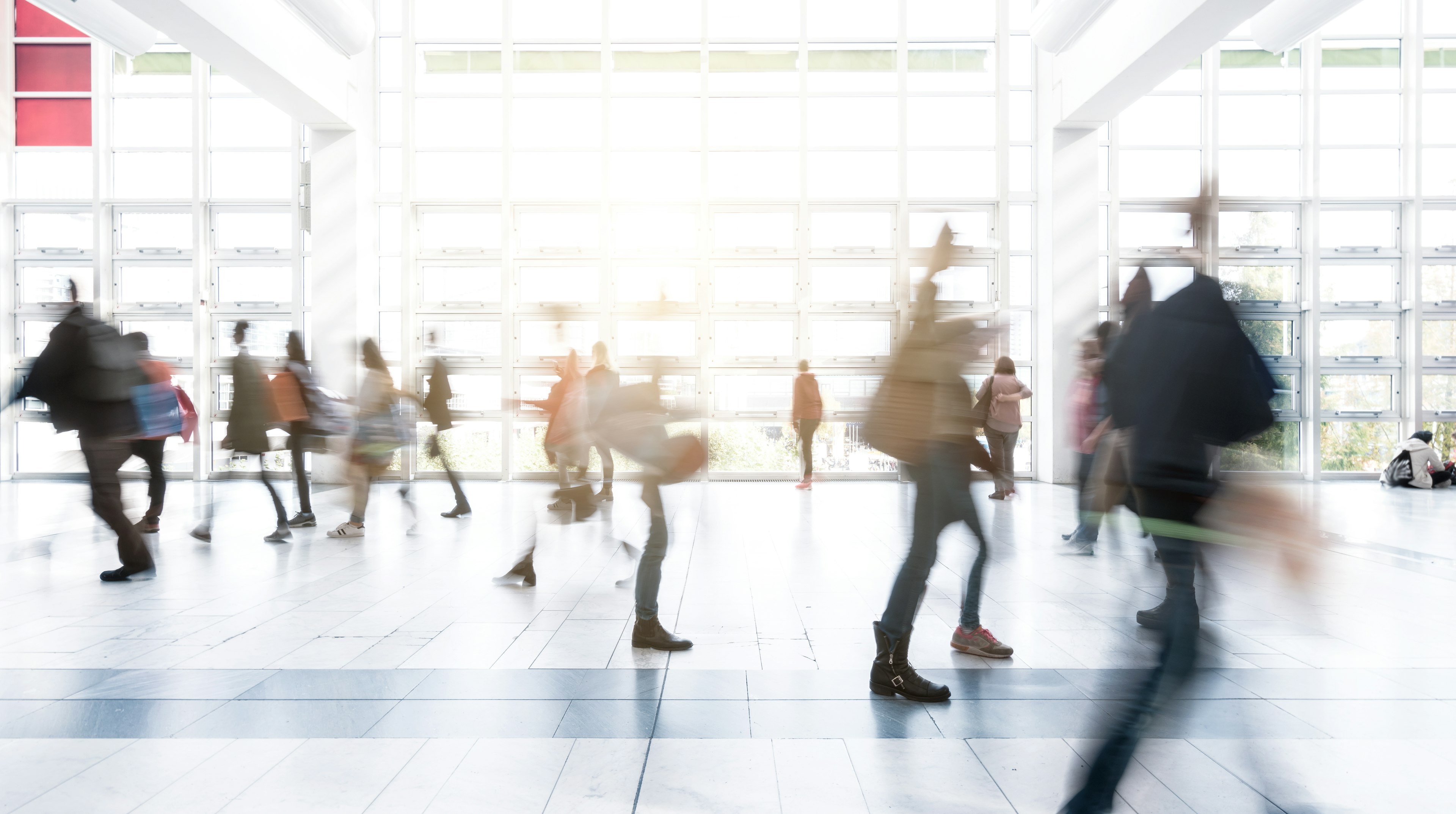 Long exposure of blurred people walking at a New York City airport.