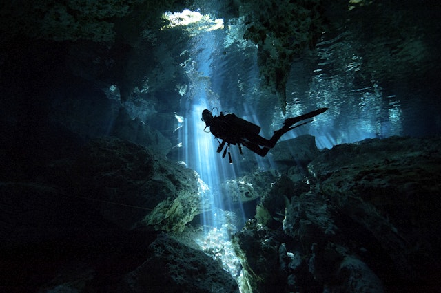 A scuba diver explores a freshwater cave in Yucatán, Mexico. Alastair Pollock Photography / Getty Images