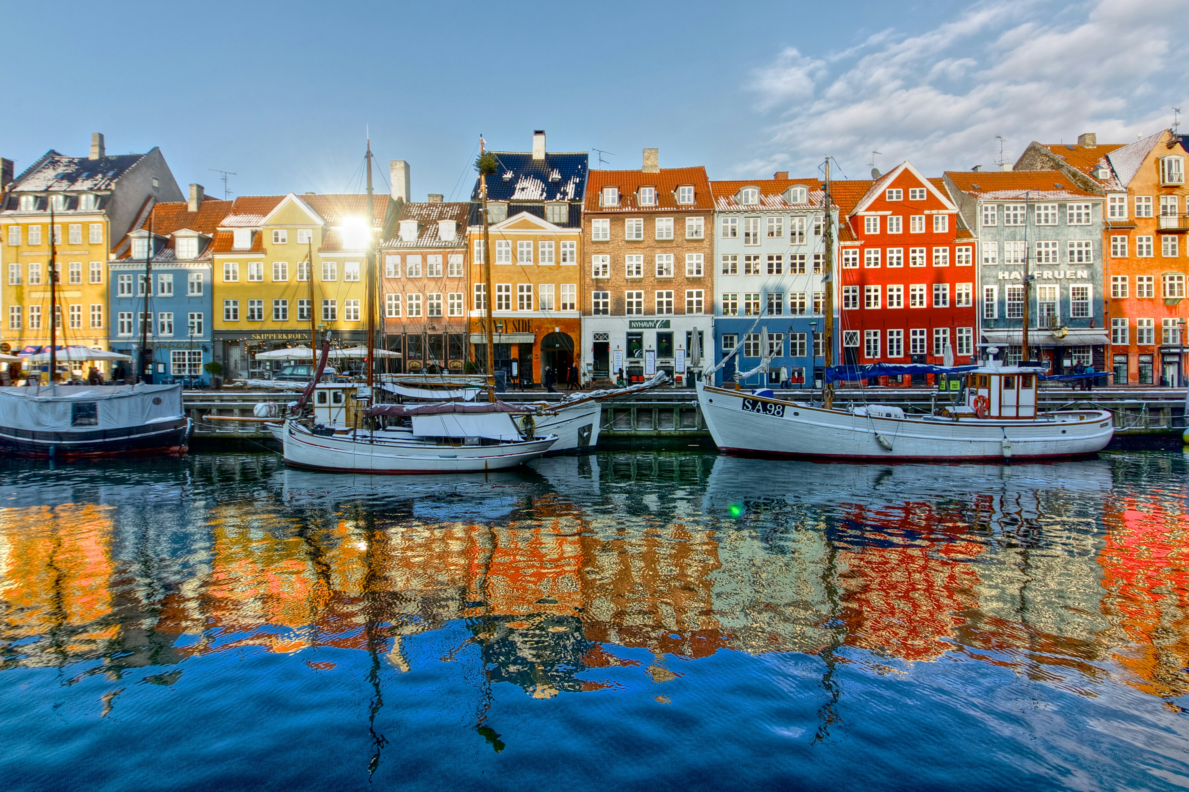 Brightly coloured waterfront facades of Nyhavn, reflected in the water below.