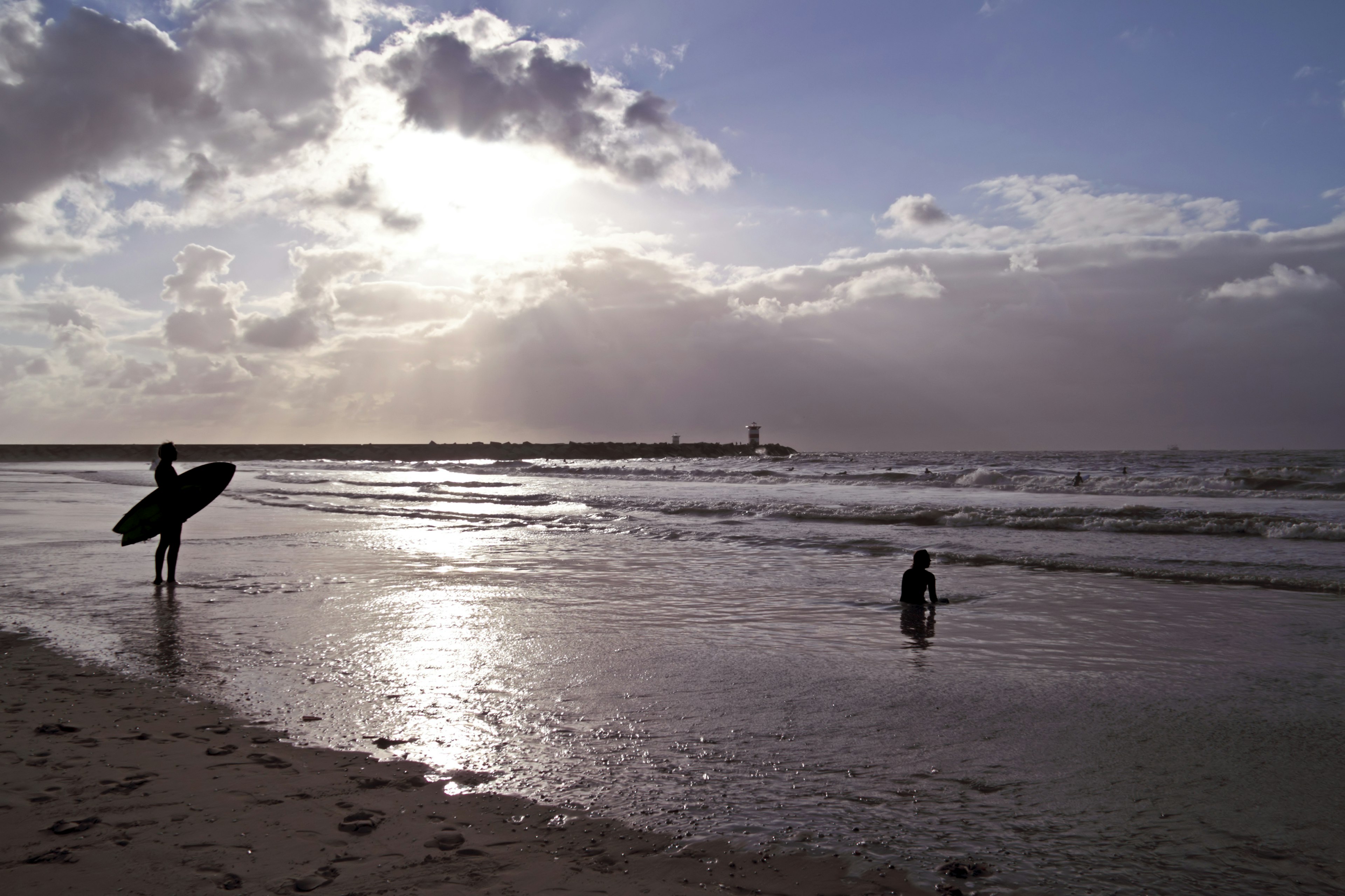 Surfer ready to surf at sunset, Scheveningen beach.