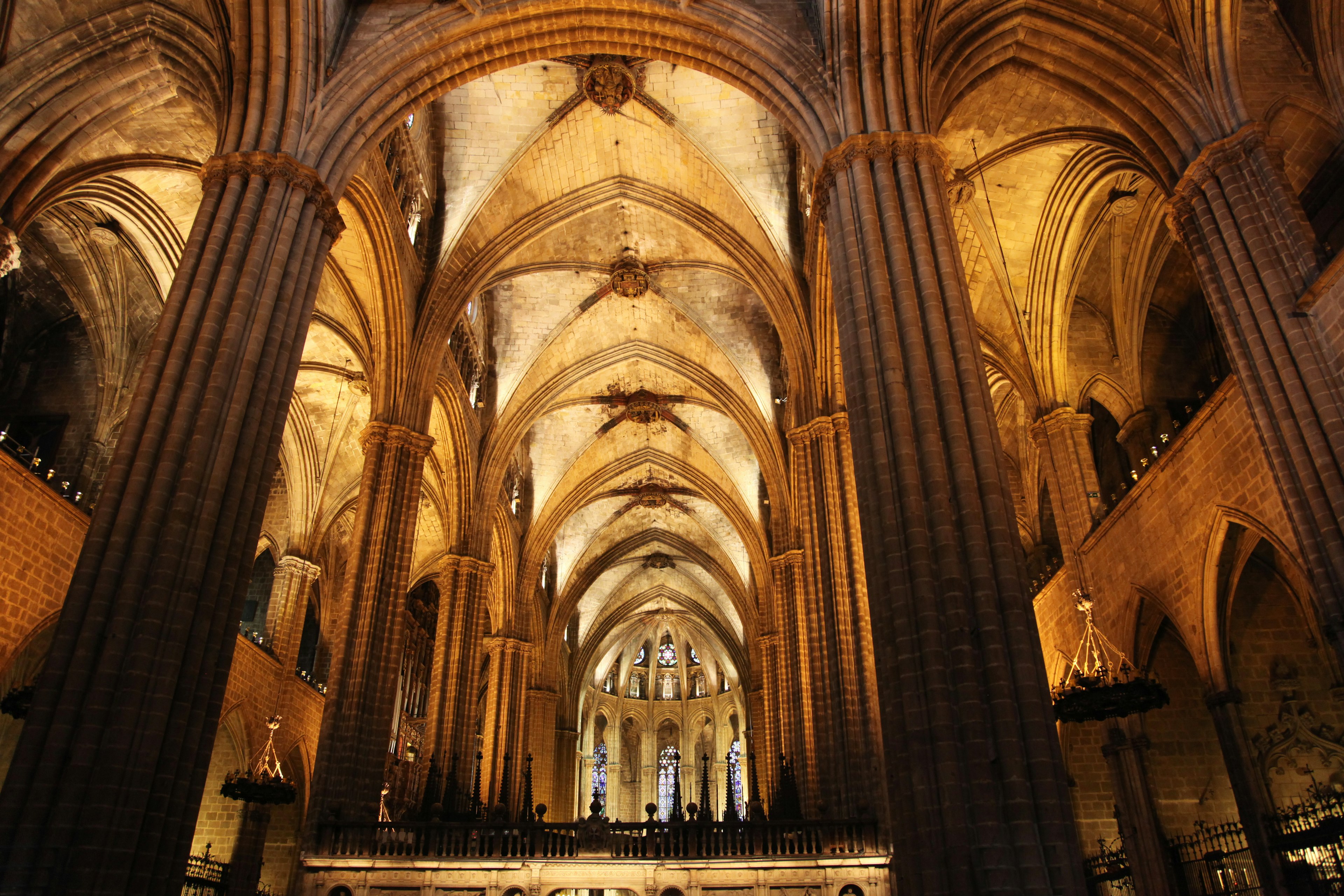 The vaulted Gothic interior of La Catedral in Barcelona, a broad, soaring space divided into a central nave and two aisles by lines of elegant, slim pillars