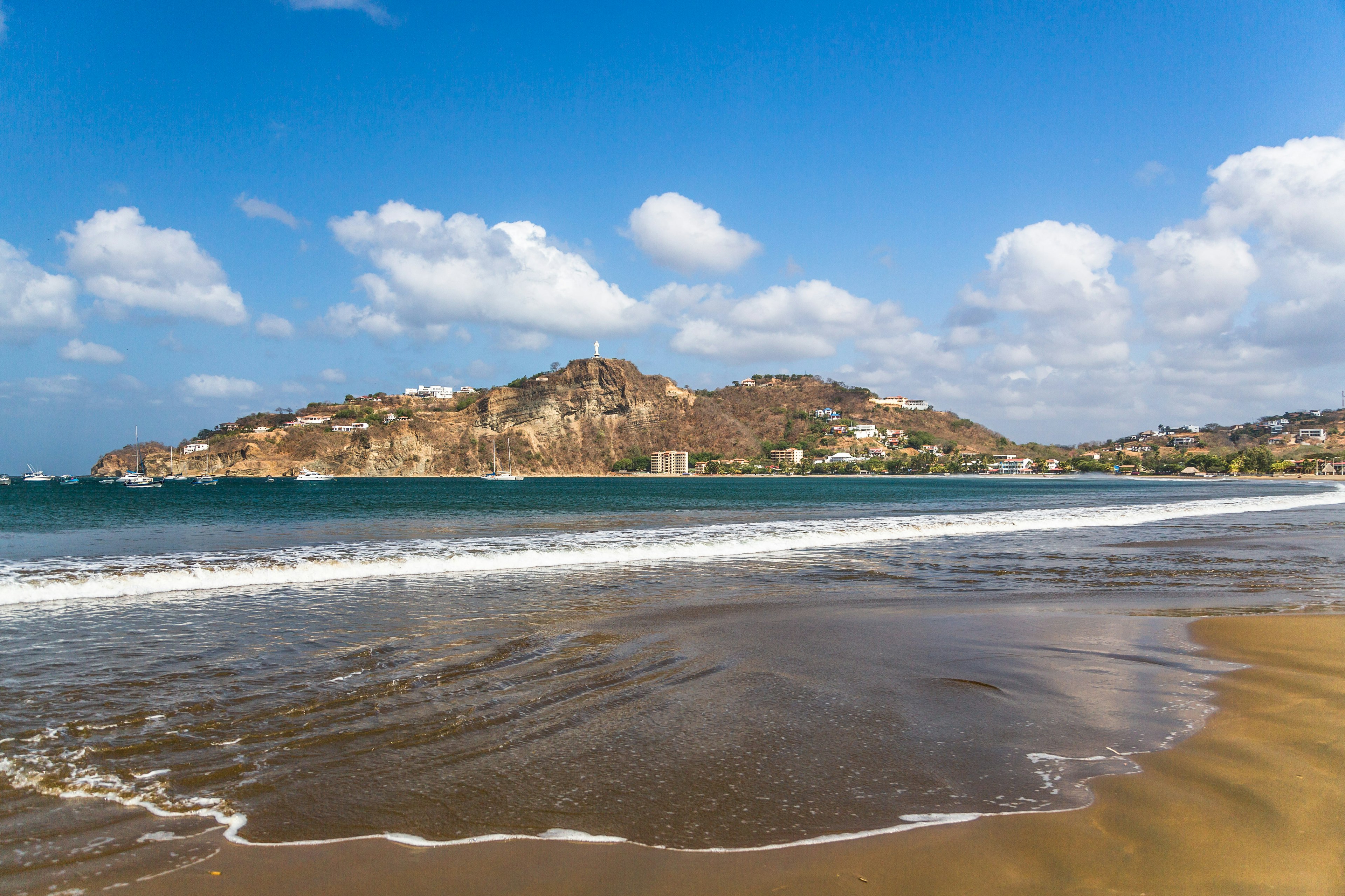 Gentle waves lap the sandy light brown shores.