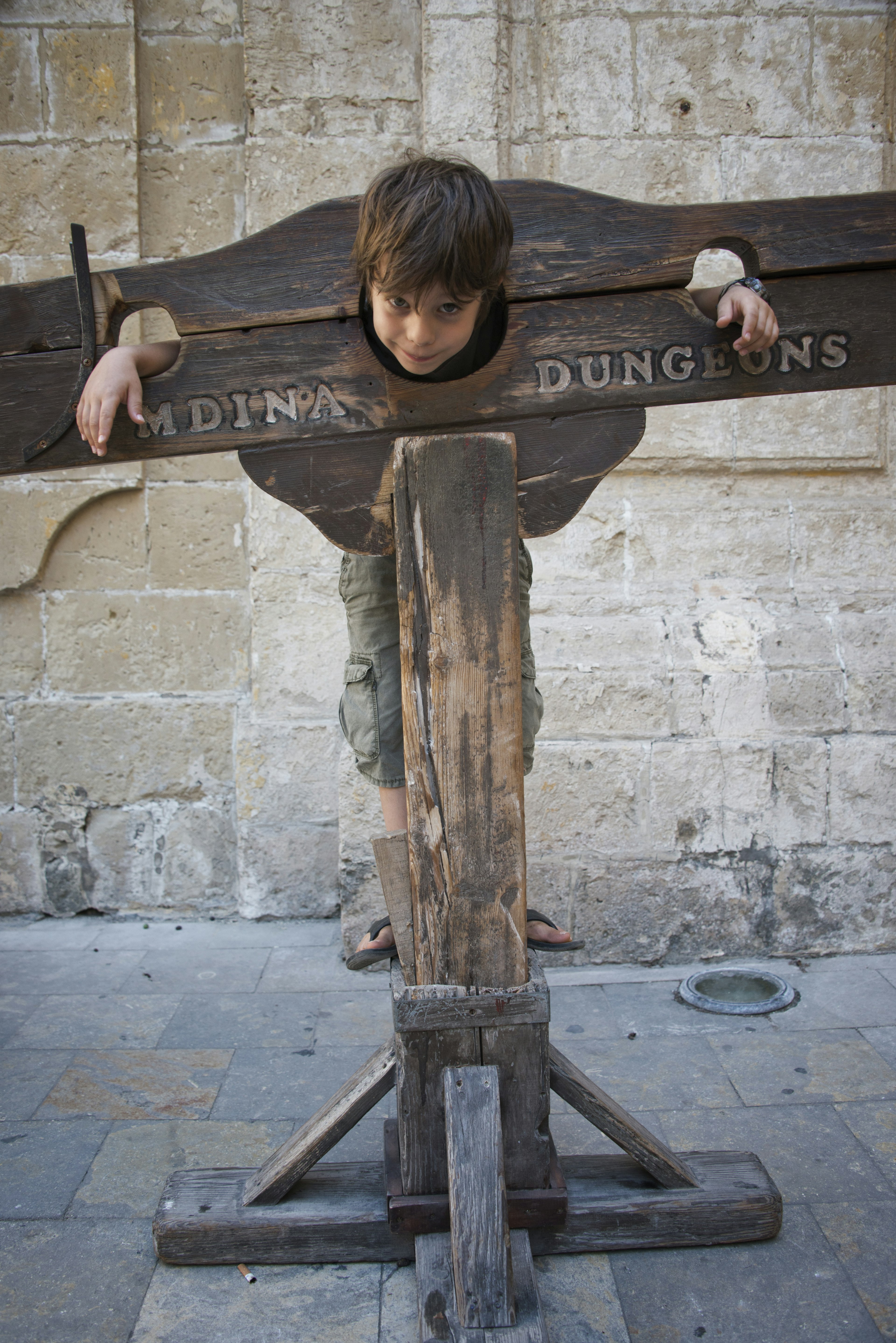 A boy trapped in a medieval torture device, Mdina, Malta