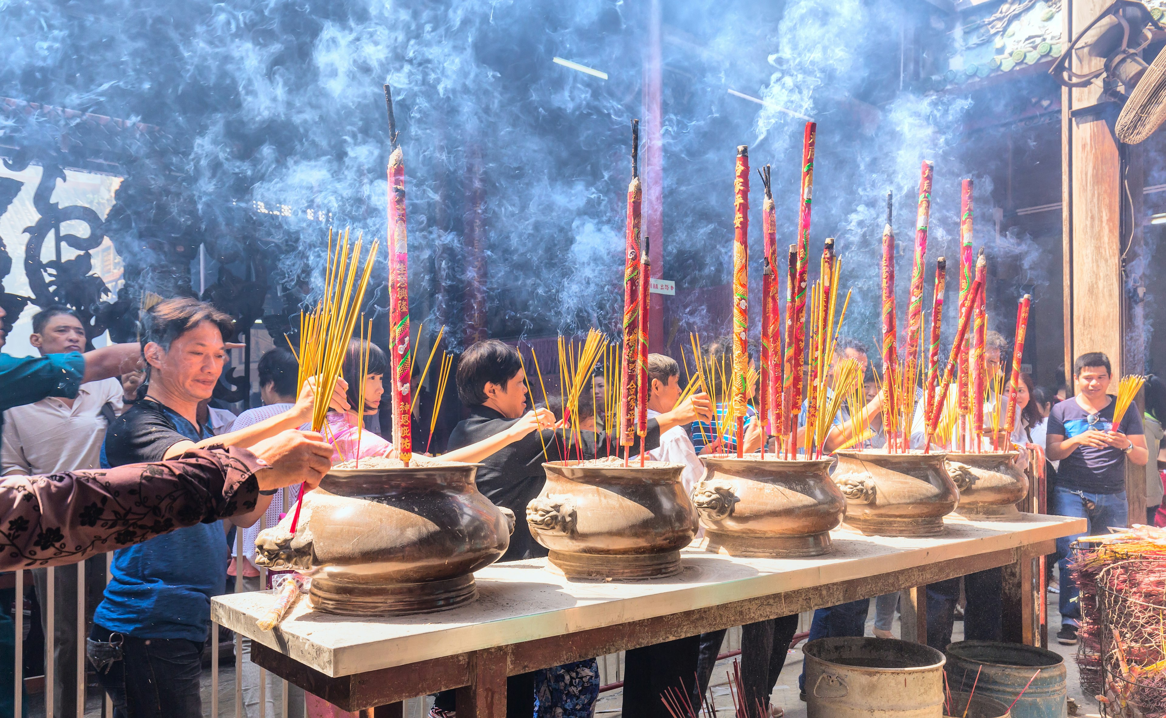 People light incense sticks in a busy temple to mark a festival