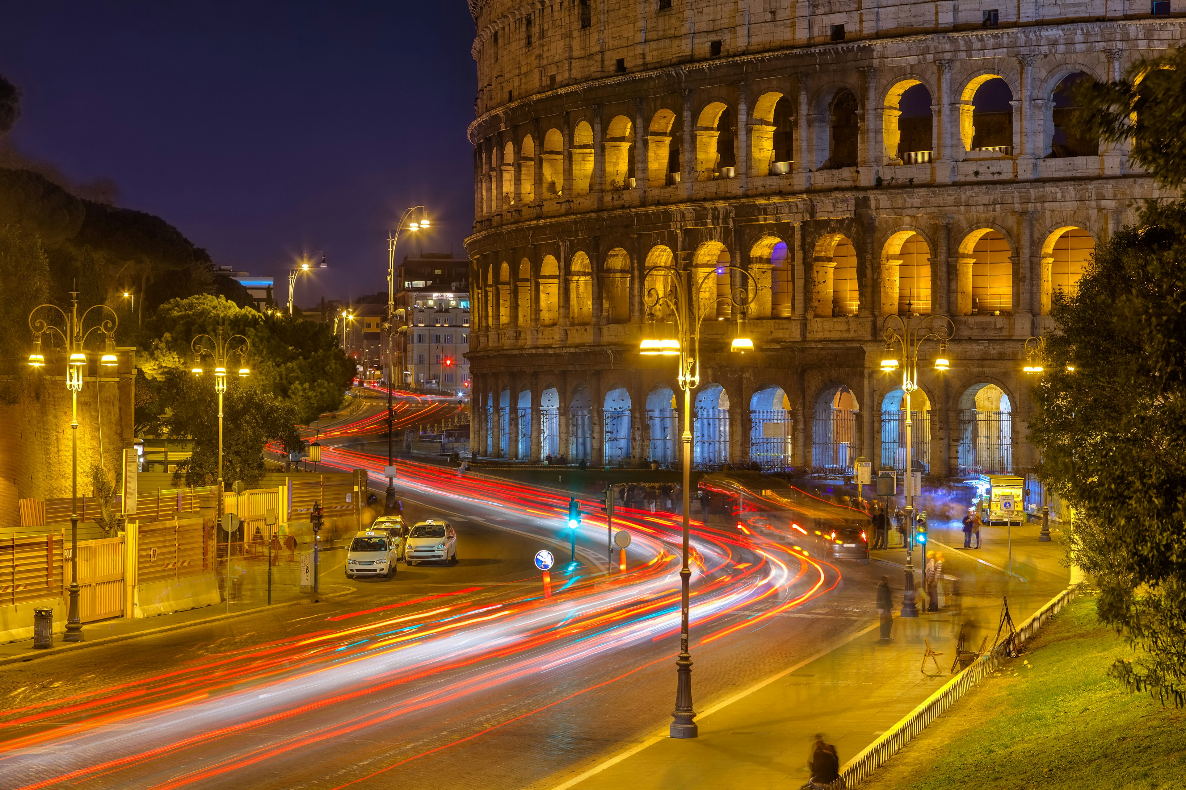 Colosseum at night, long exposure with cars streaking by.