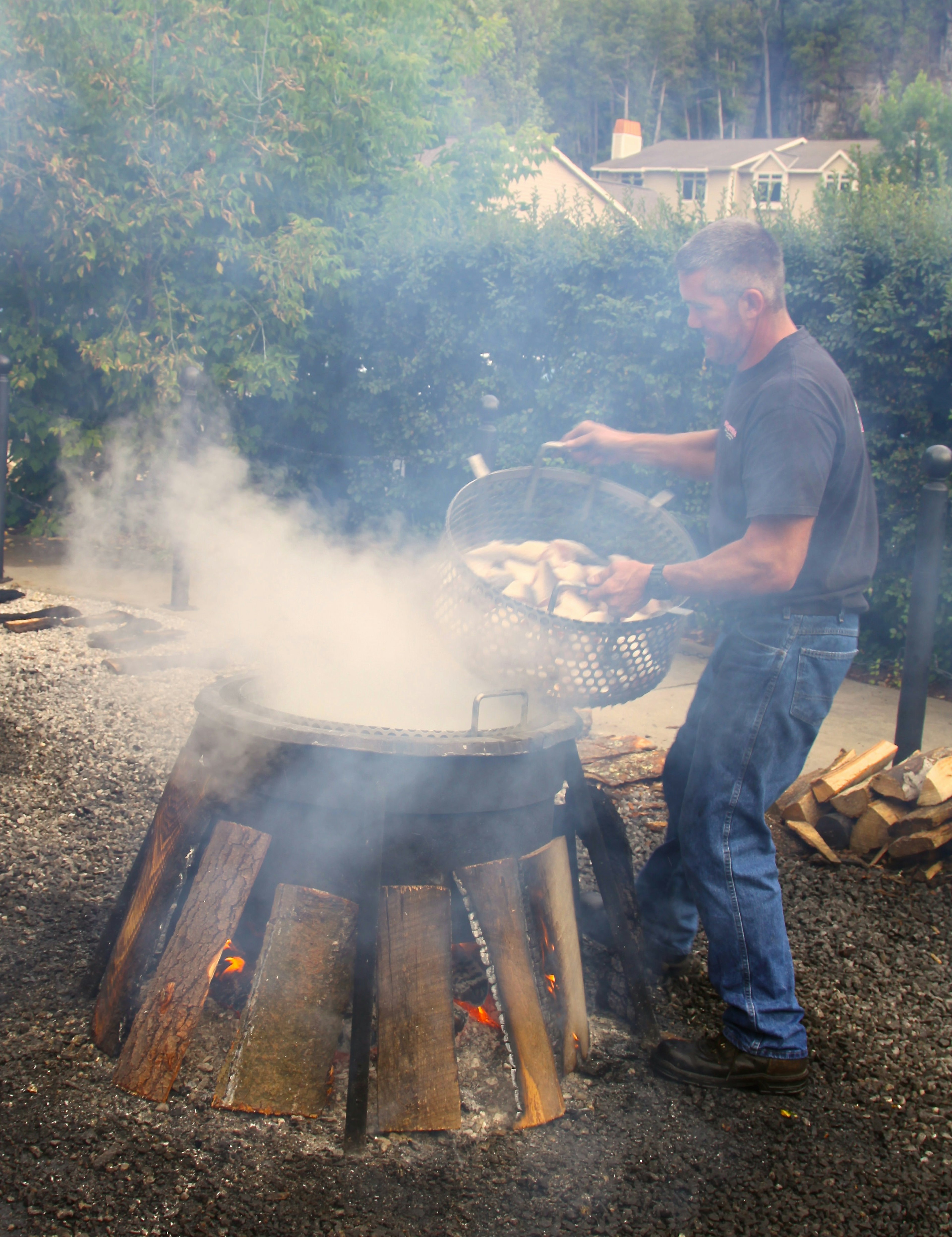 Putting a colander of fish into a boiling pot at a Door County Fish Boil