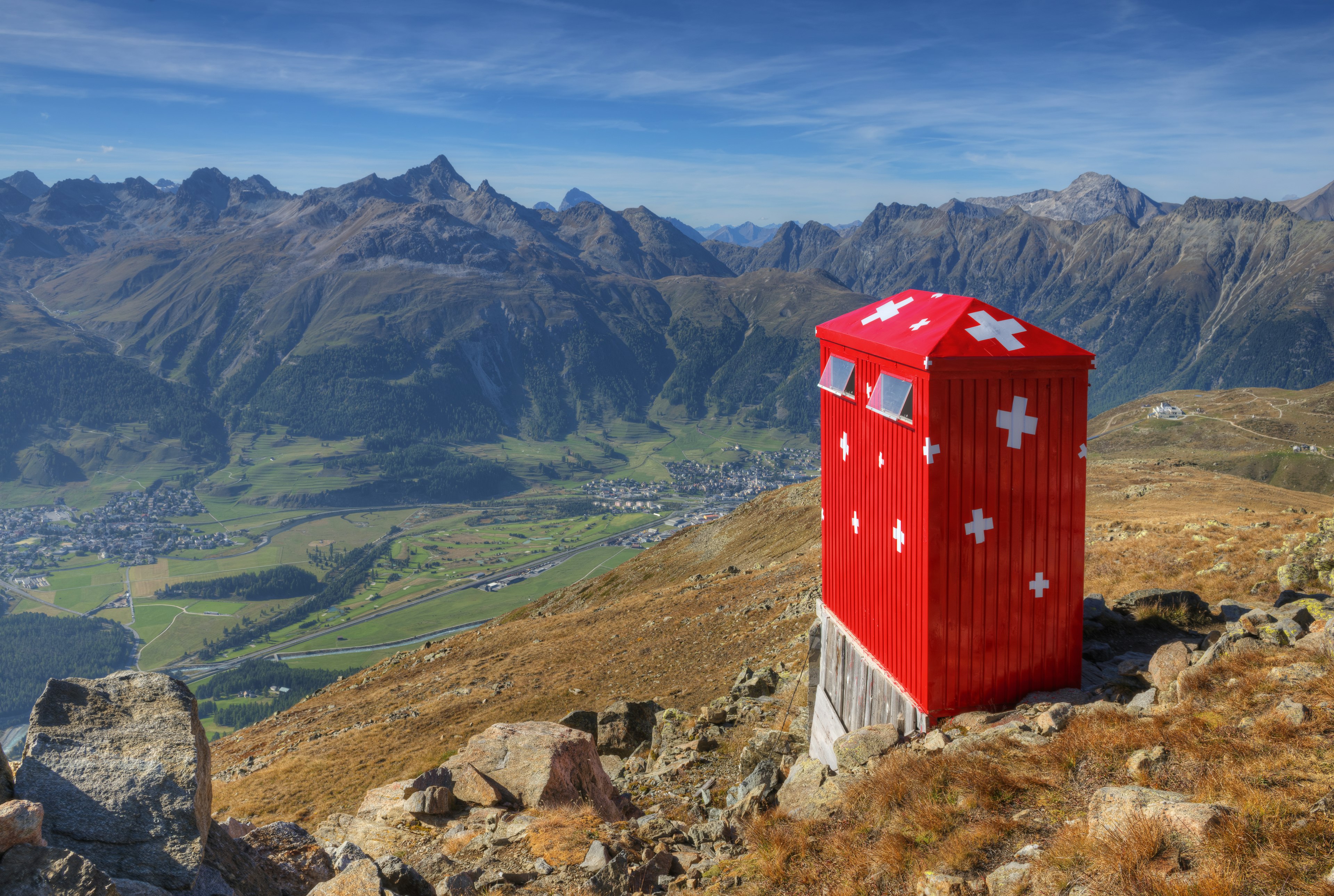 A red toilet overlooking a deep valley