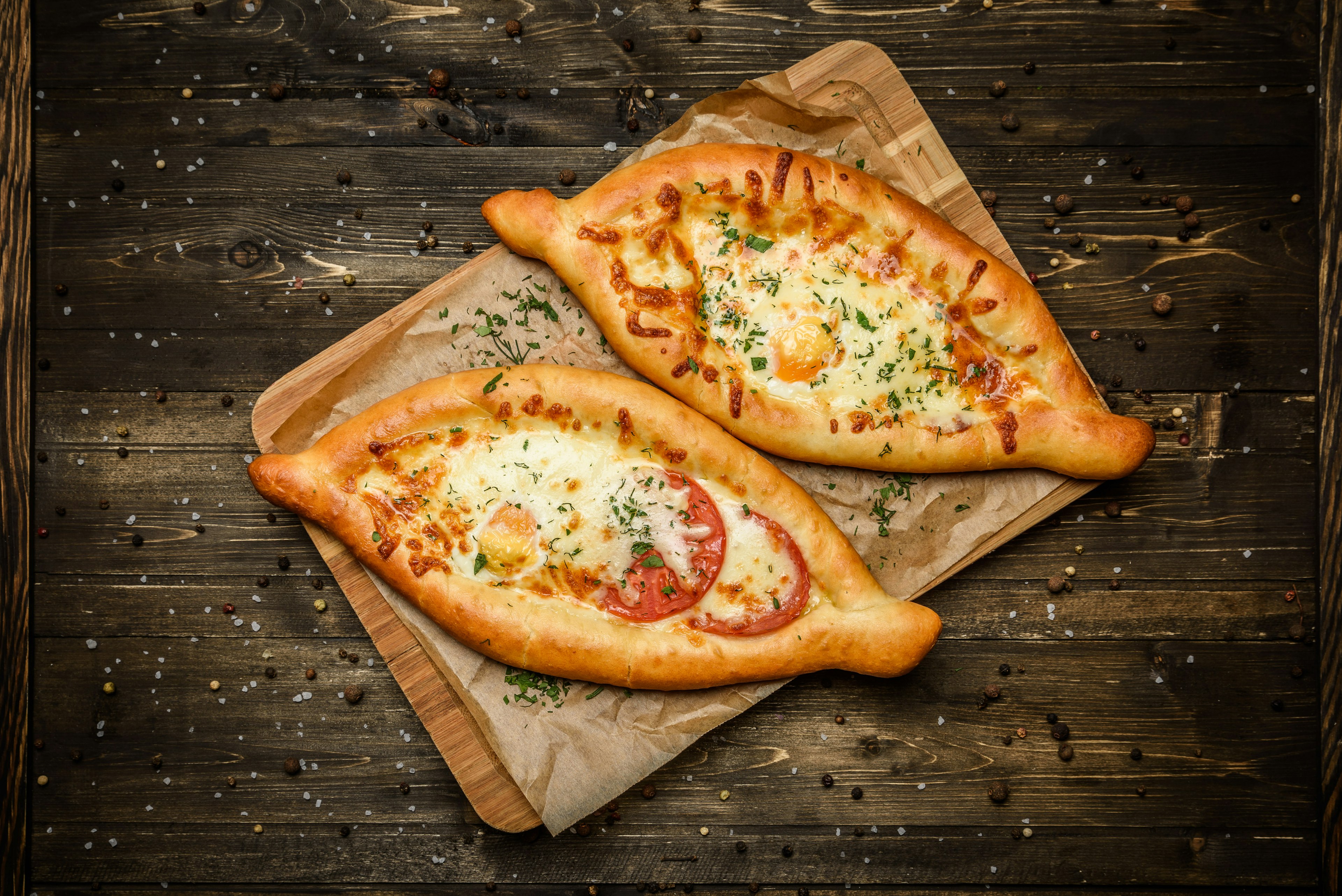 Two boat-shaped pastries with an egg baked on top