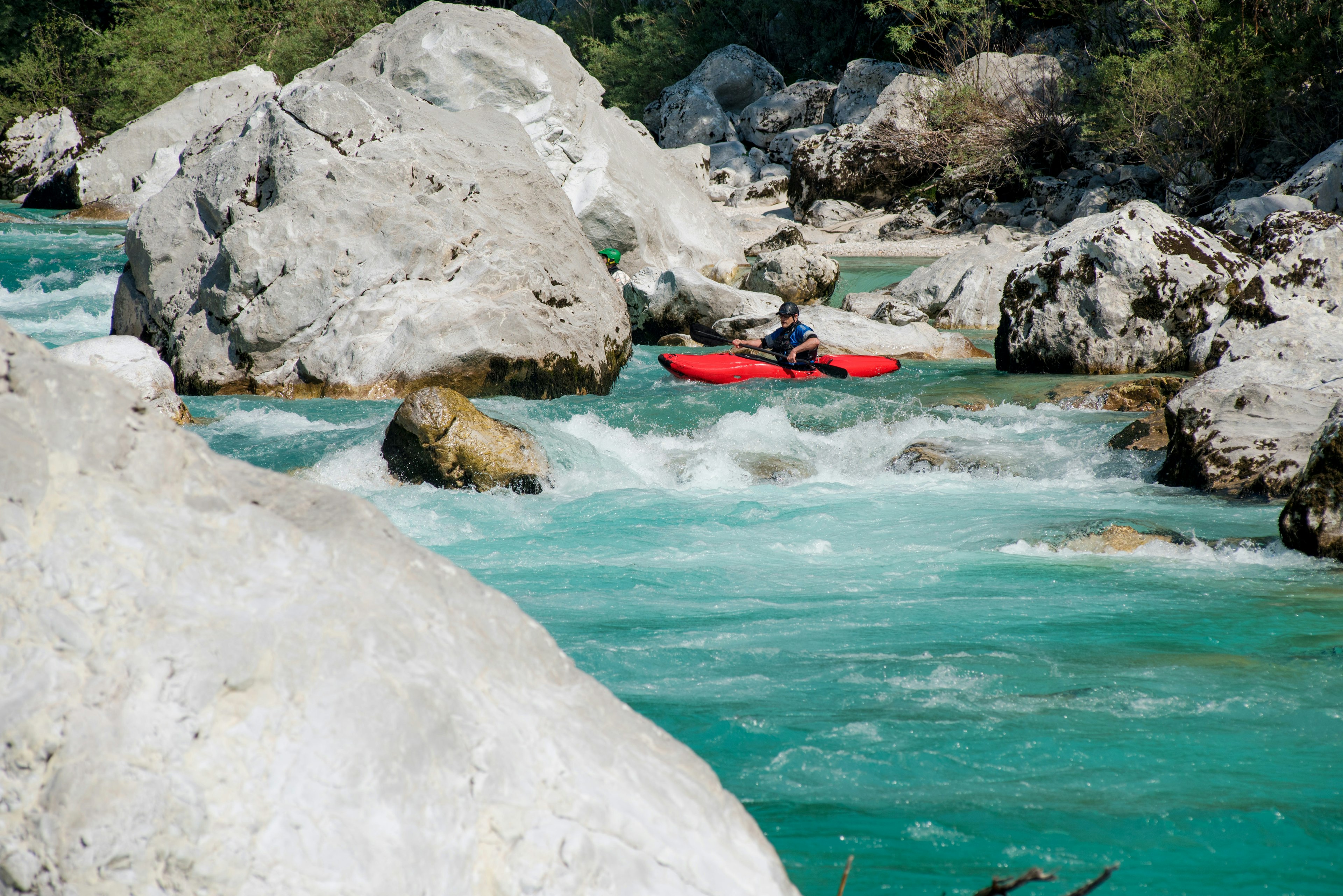 A man kayaking in the turquoise water of the river Soca, in Slovenia.