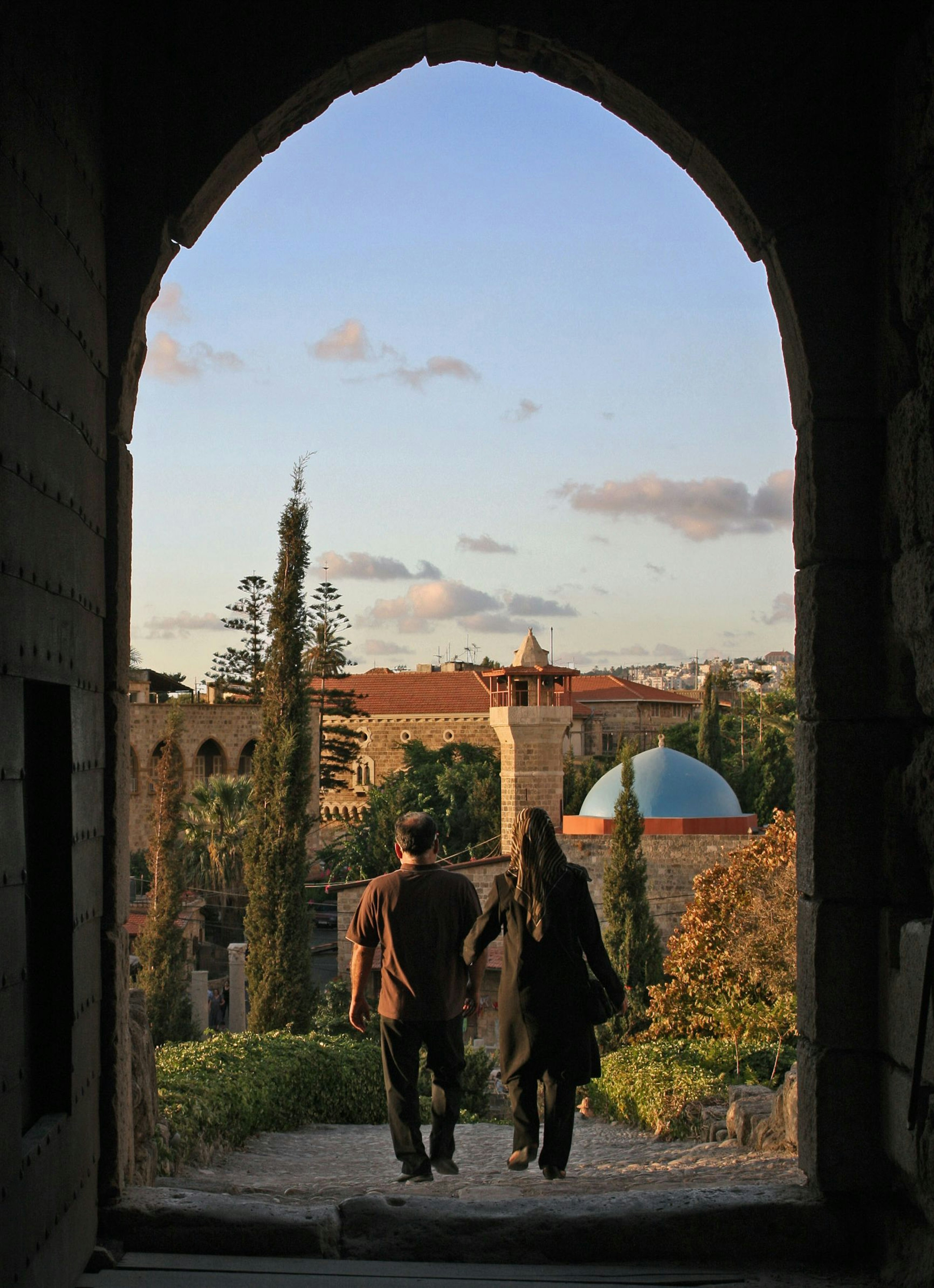 A couple leaving the castle of Byblos, Lebanon, at dusk