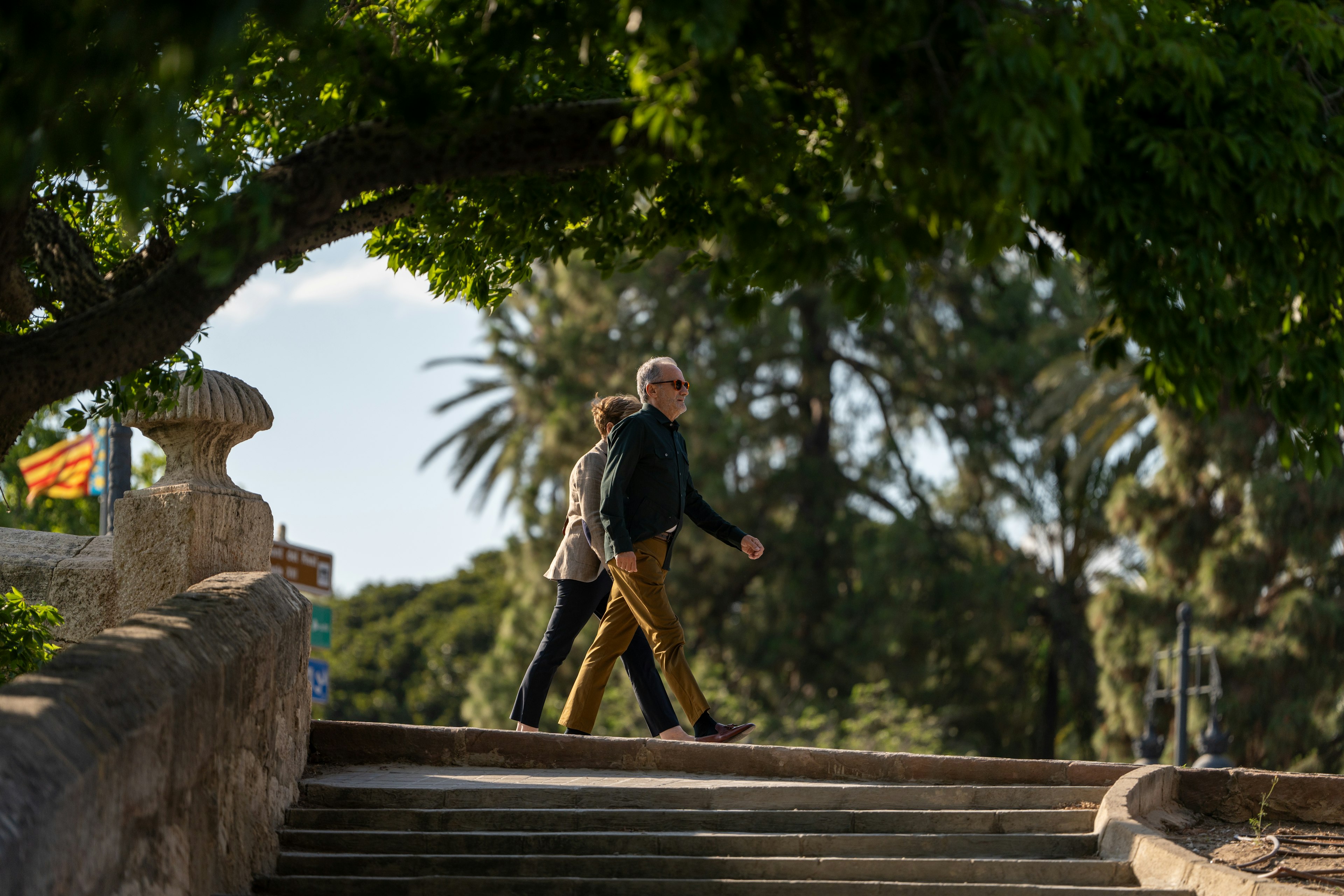 A man and woman walk by steps in the Jardines del Turia, Valencia, Spain