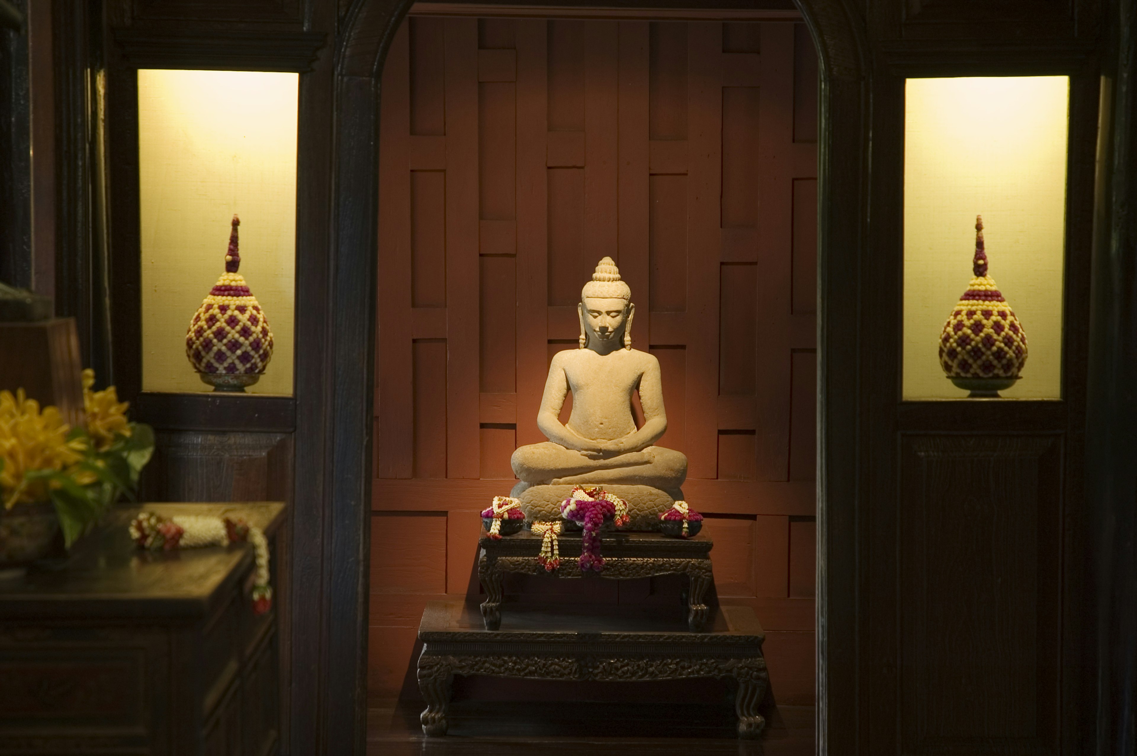 23281-69 Азия, Бангкок, Юго-Восточная Азия, Таиланд, искусство, коричневый, буддийский, спокойствие, цвет, культура, день, декор, фигура, флора, цветок, вид спереди, полноразмерный, мебель, интерьер, свет, средняя группа объектов, нет людей, преданность, растение, молитва, религия, культуры, скульптура, место, сидеть, духовность, статуя, дерево, спокойствие, окно, дерево, поклонение Буддийская статуя внутри Дома Джима Томпсона.