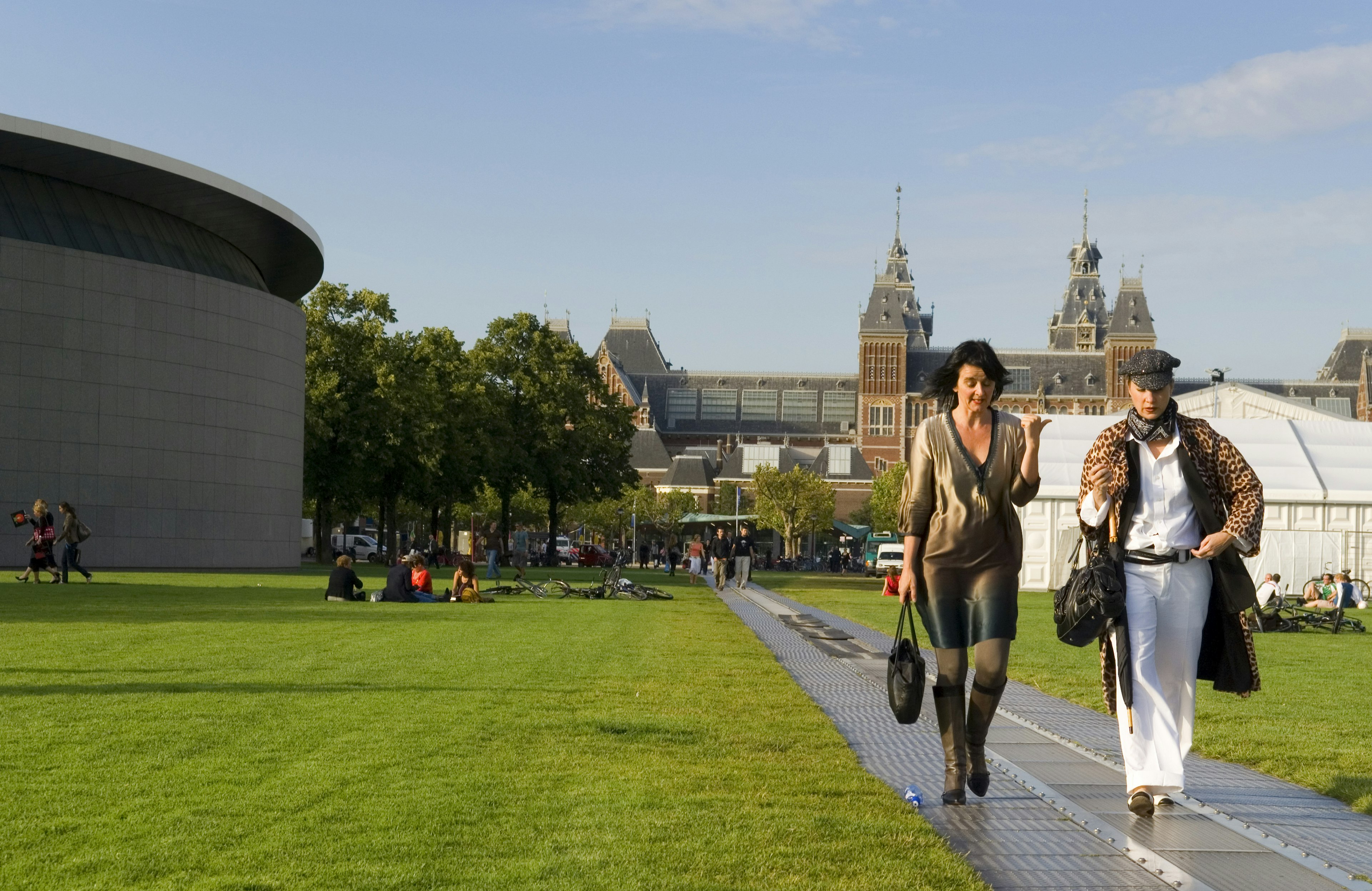 Women walking on Museumplein with Rijksmuseum in background.