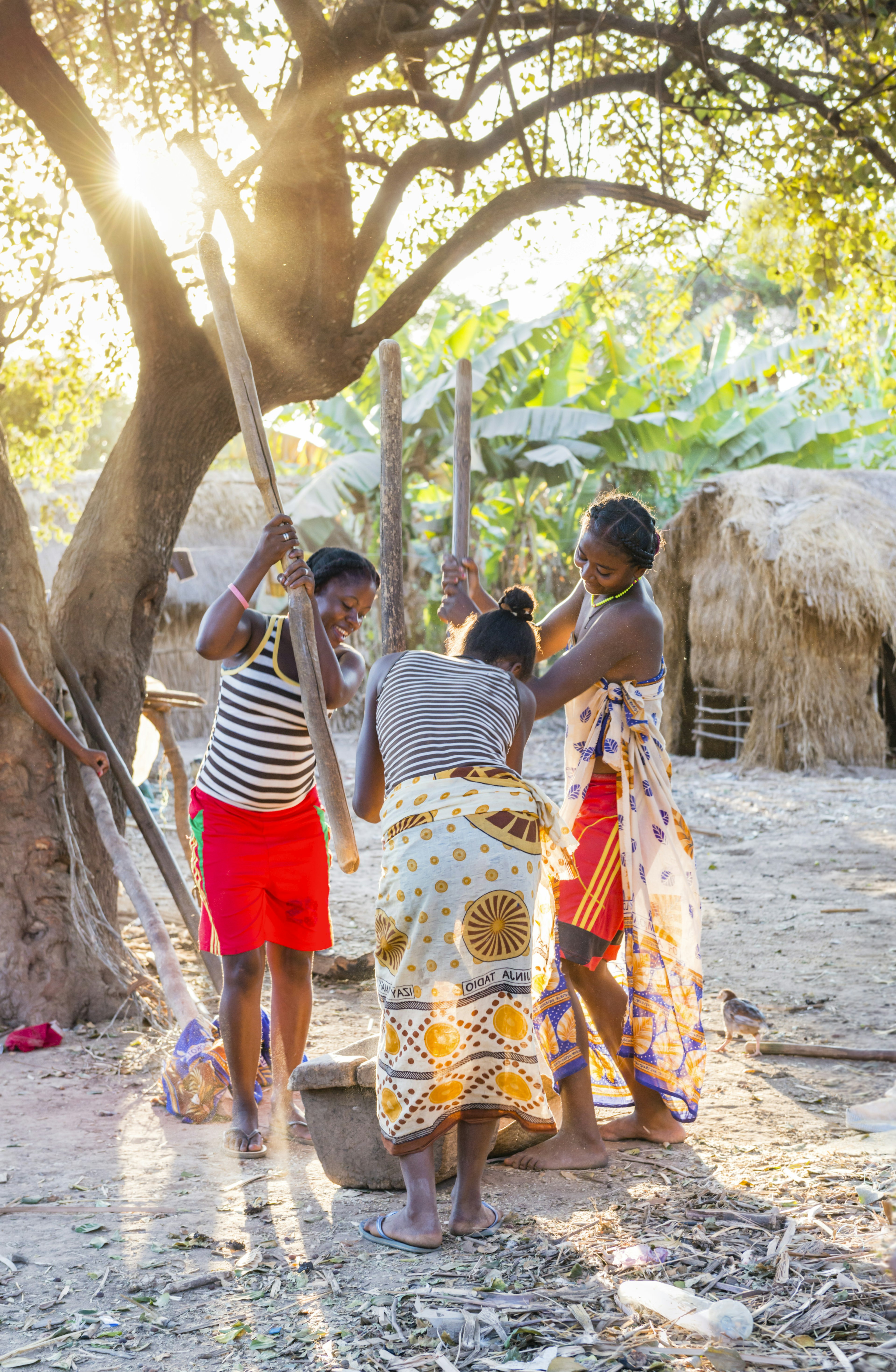 Women pounding rice in a village along the 8a road.