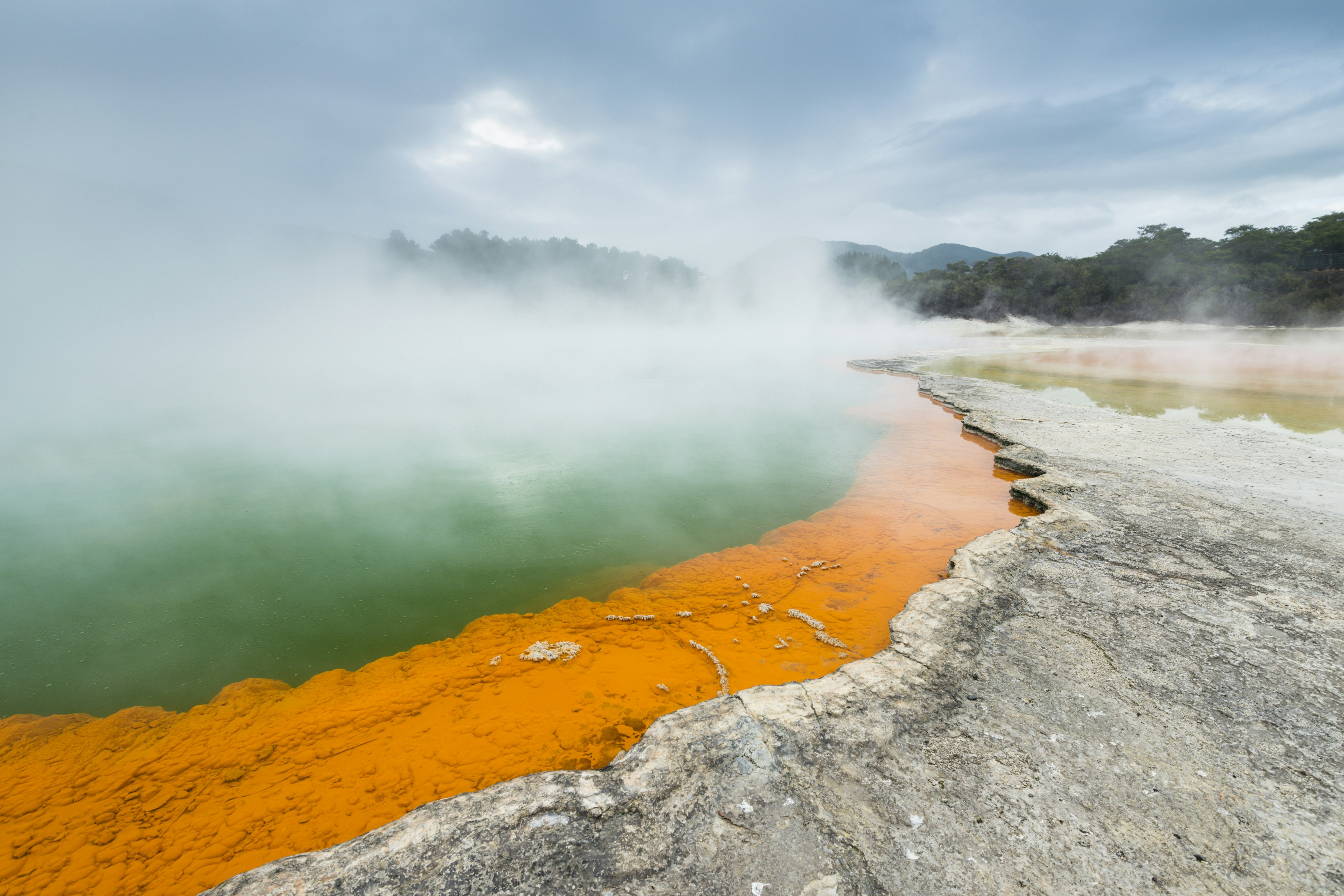 Image of a body of water surrounded by an orange rock deposit.