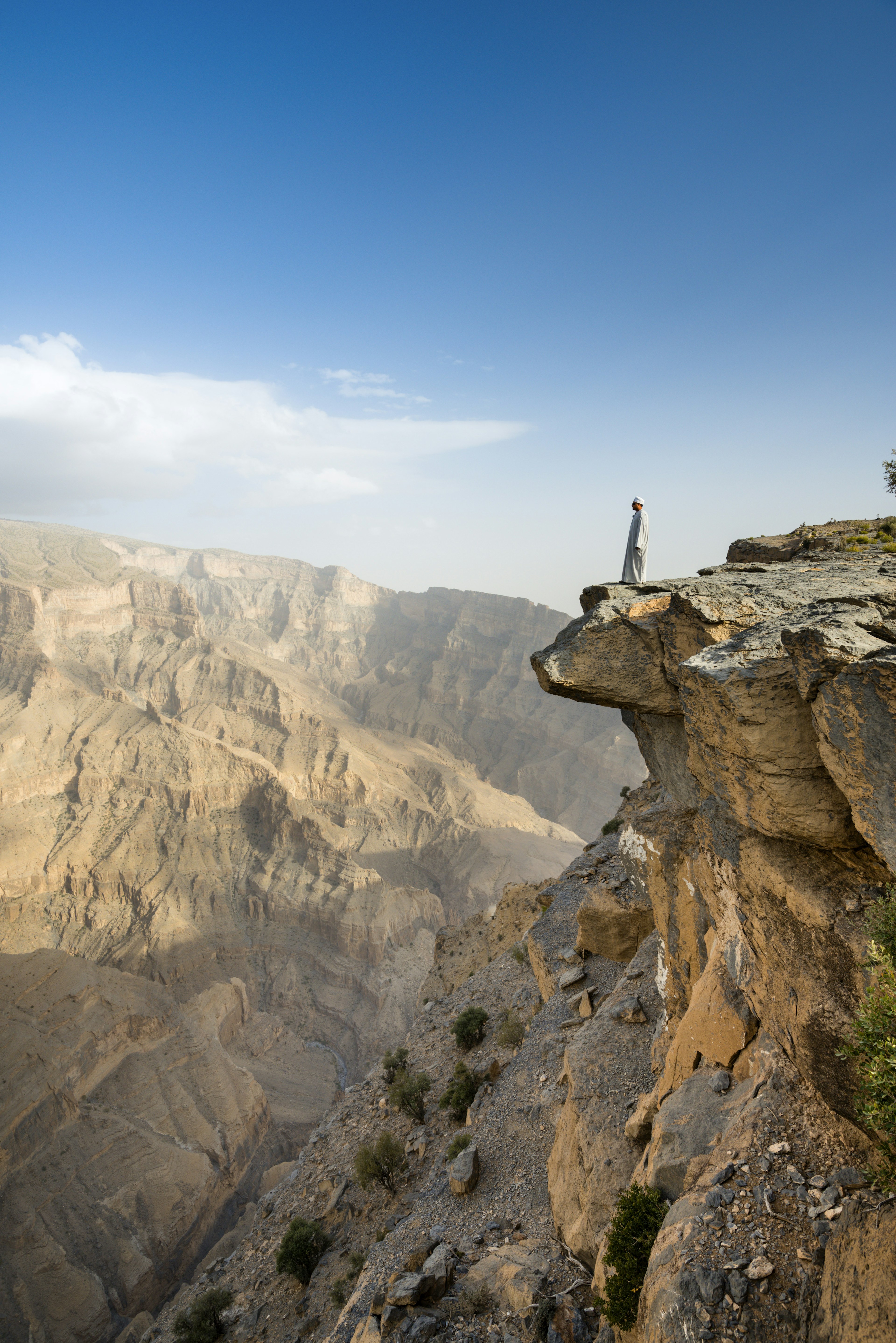 A local man fearlessly inspects Wadi Ghul,.the so-called ‘Grand Canyon of Arabia’, from the top of Jebel Shams