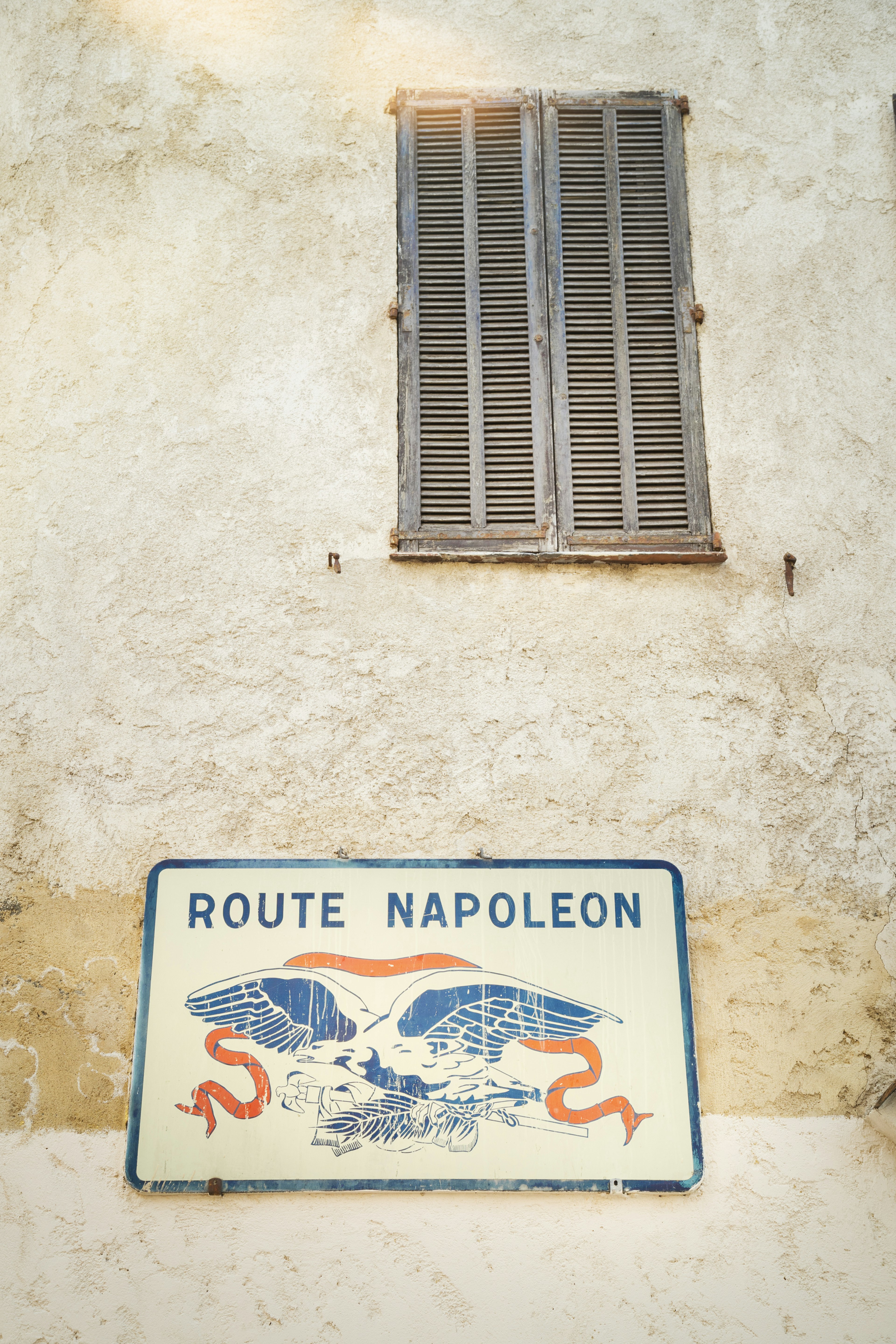 An eagle marks a road sign at the start of the Route Napoléon