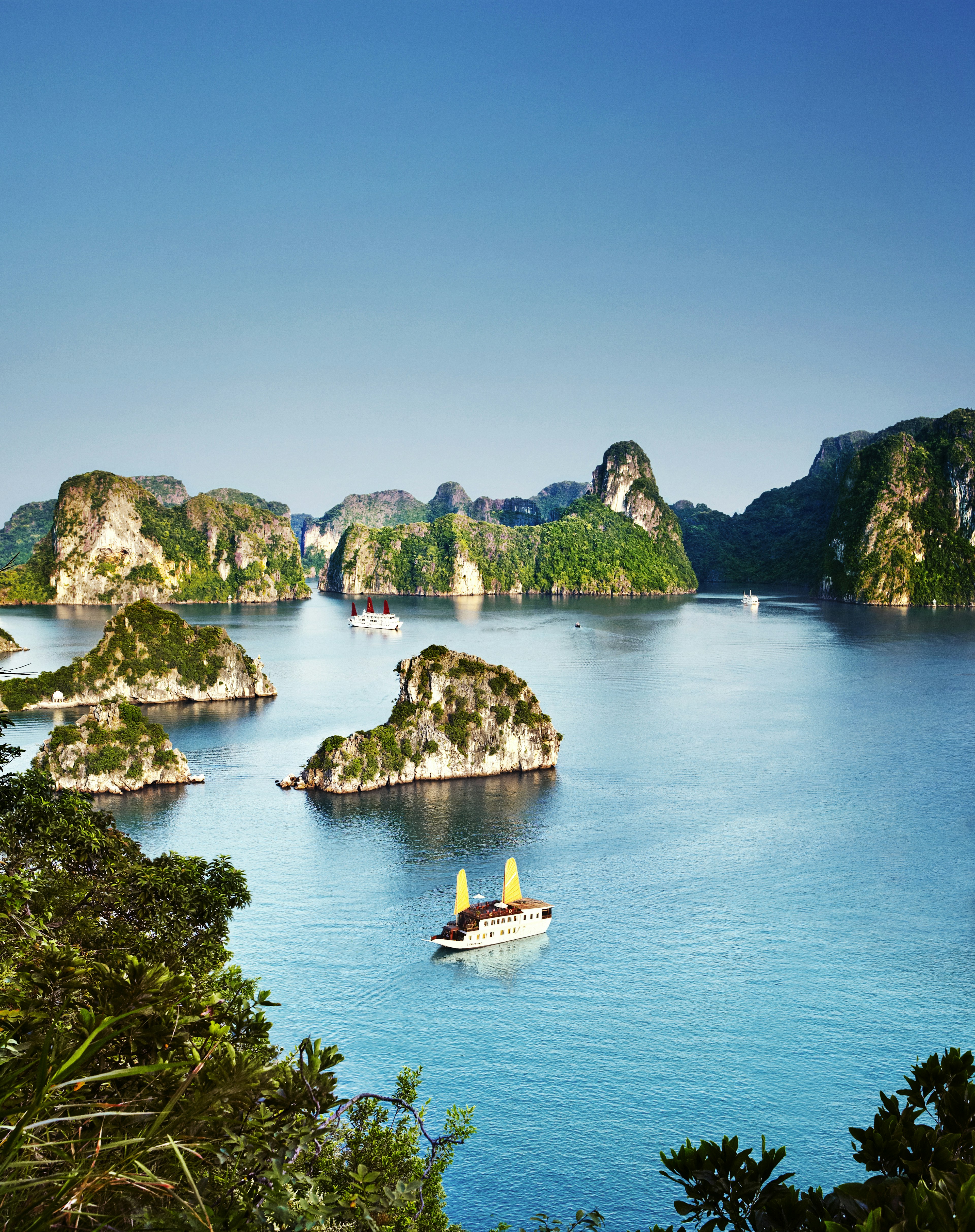 Chinese junks cruise by limestone islands in Halong Bay