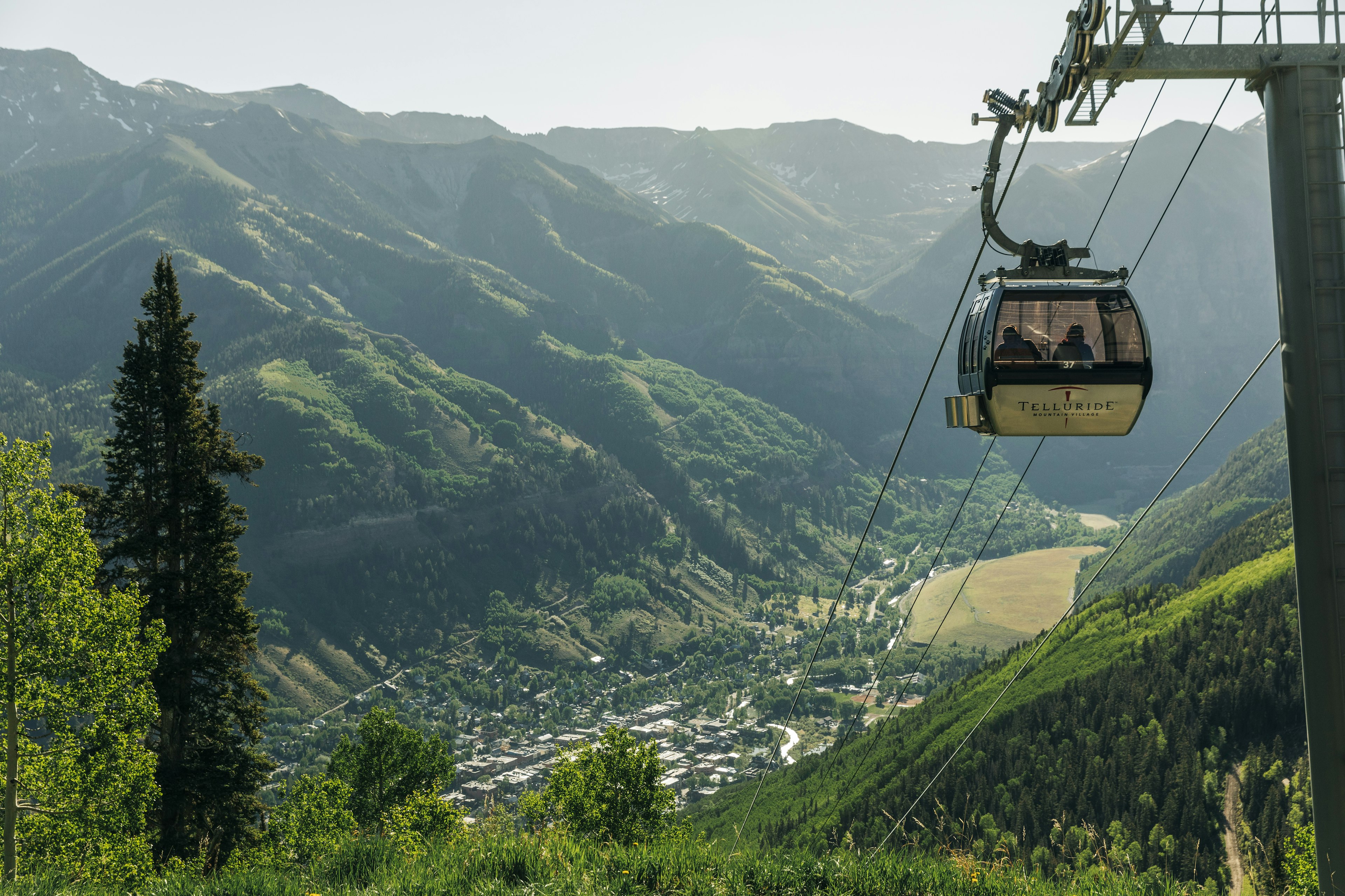 A gondola ascends a mountain slope from the town of Telluride to Mountain Village, Colorado, USA