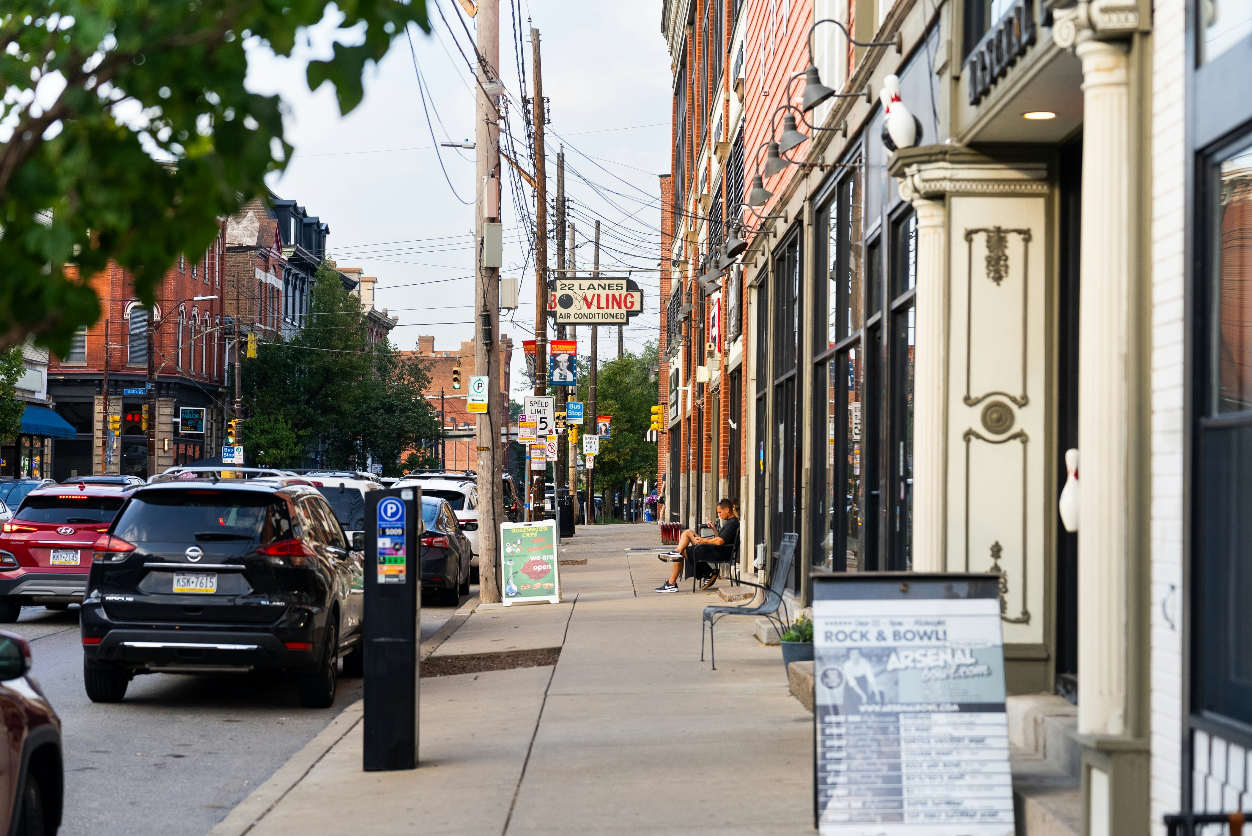 A neighborhood street in Pittsburgh features a bowling alley and shops