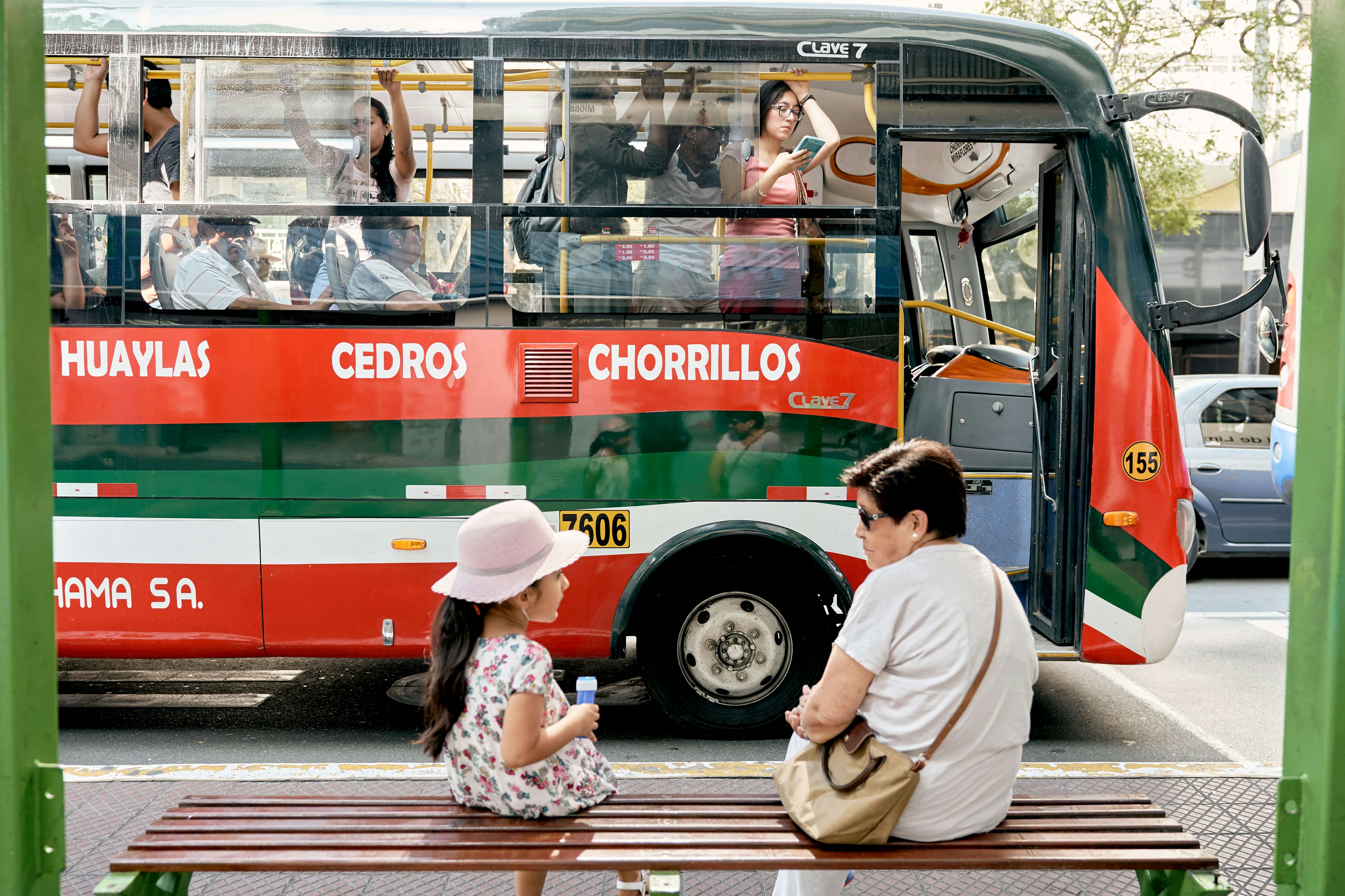 A mother and daughter wait for public transportation in Peru.