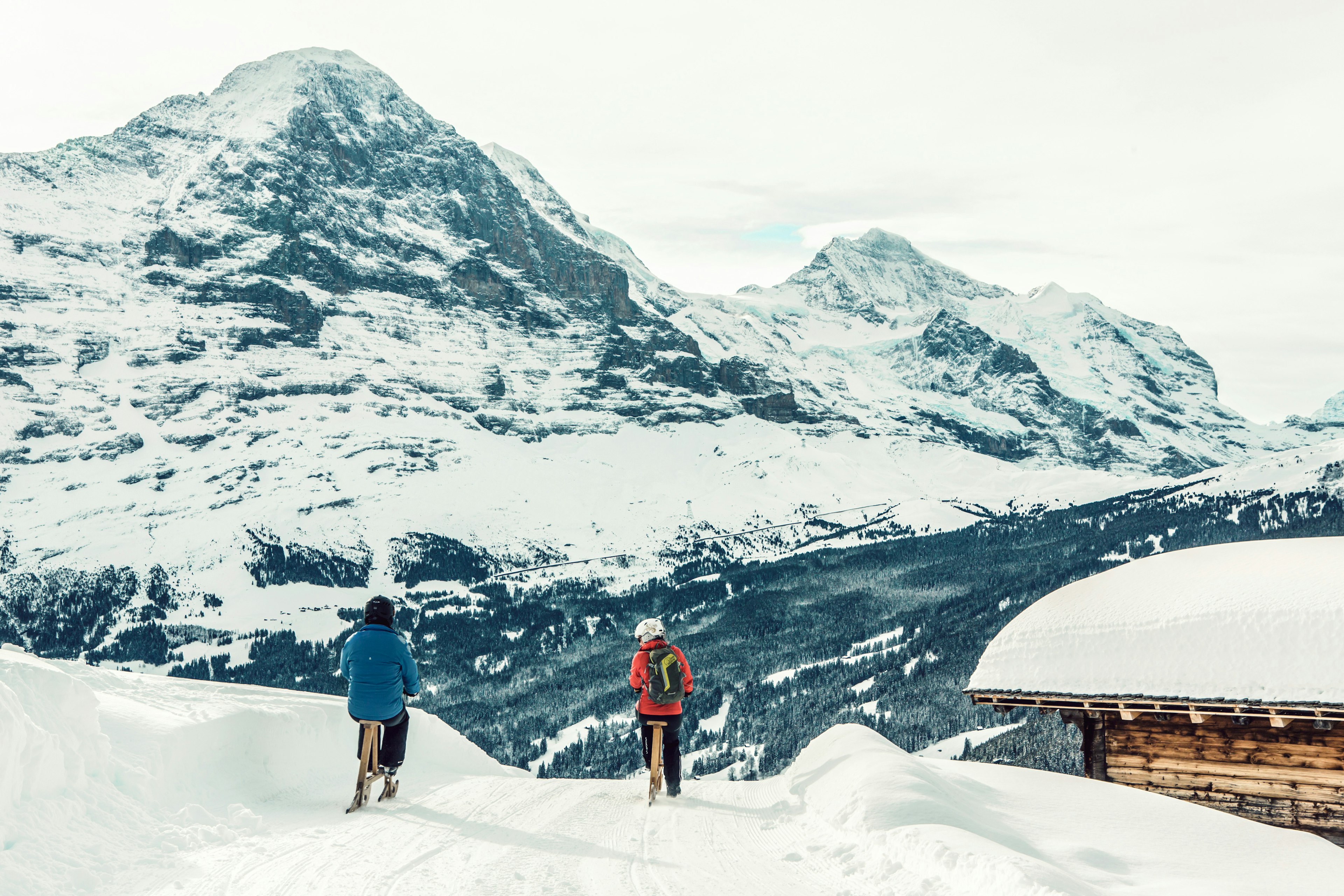 Two people ride velogemel in front of amazing mountains of Grindelwald.