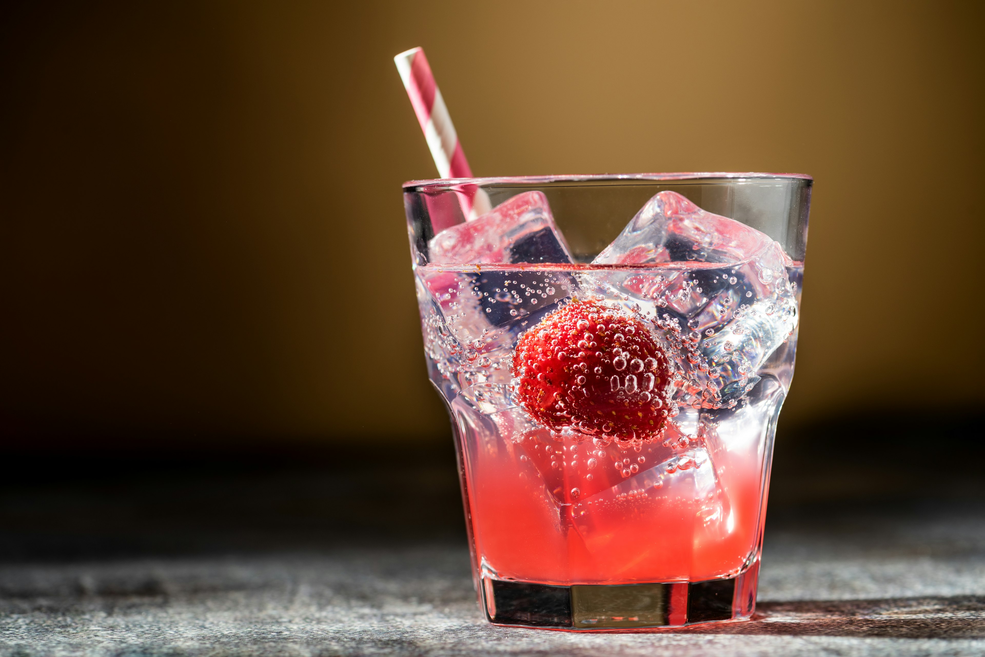 Close up image of a Shirley strawberry ginger mocktail, dramatic lighting.