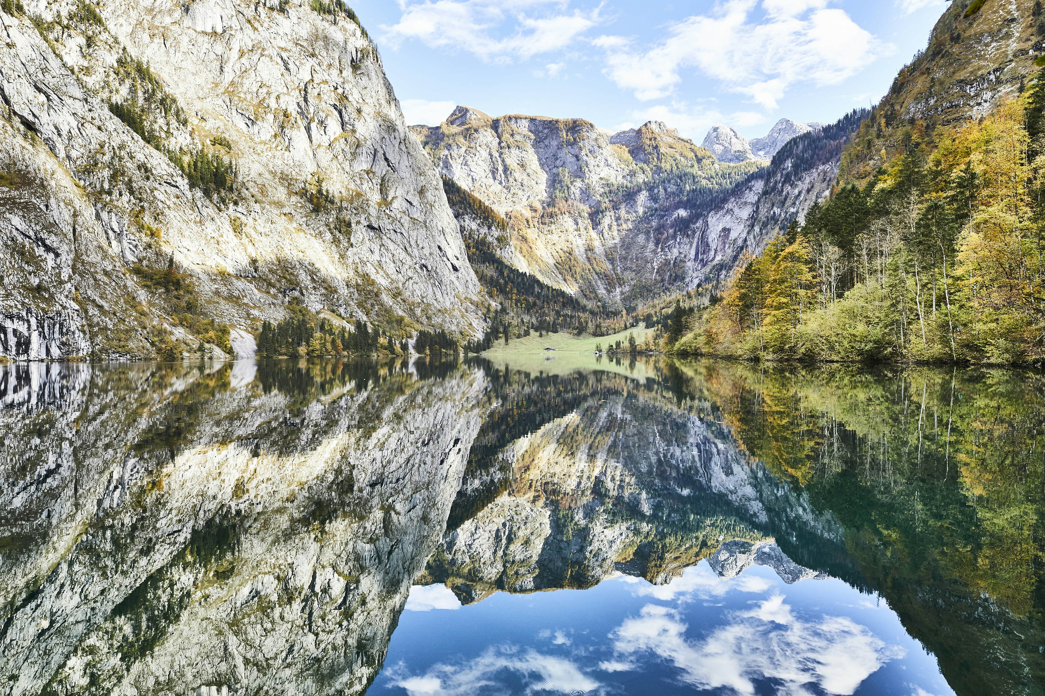 A mountain range and soft blue sky is reflected perfectly in the clear water of the Königssee, in Germany's Bavaria region.