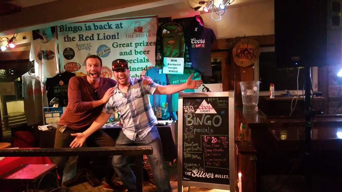 Two people on a stage in front of a BINGO sign