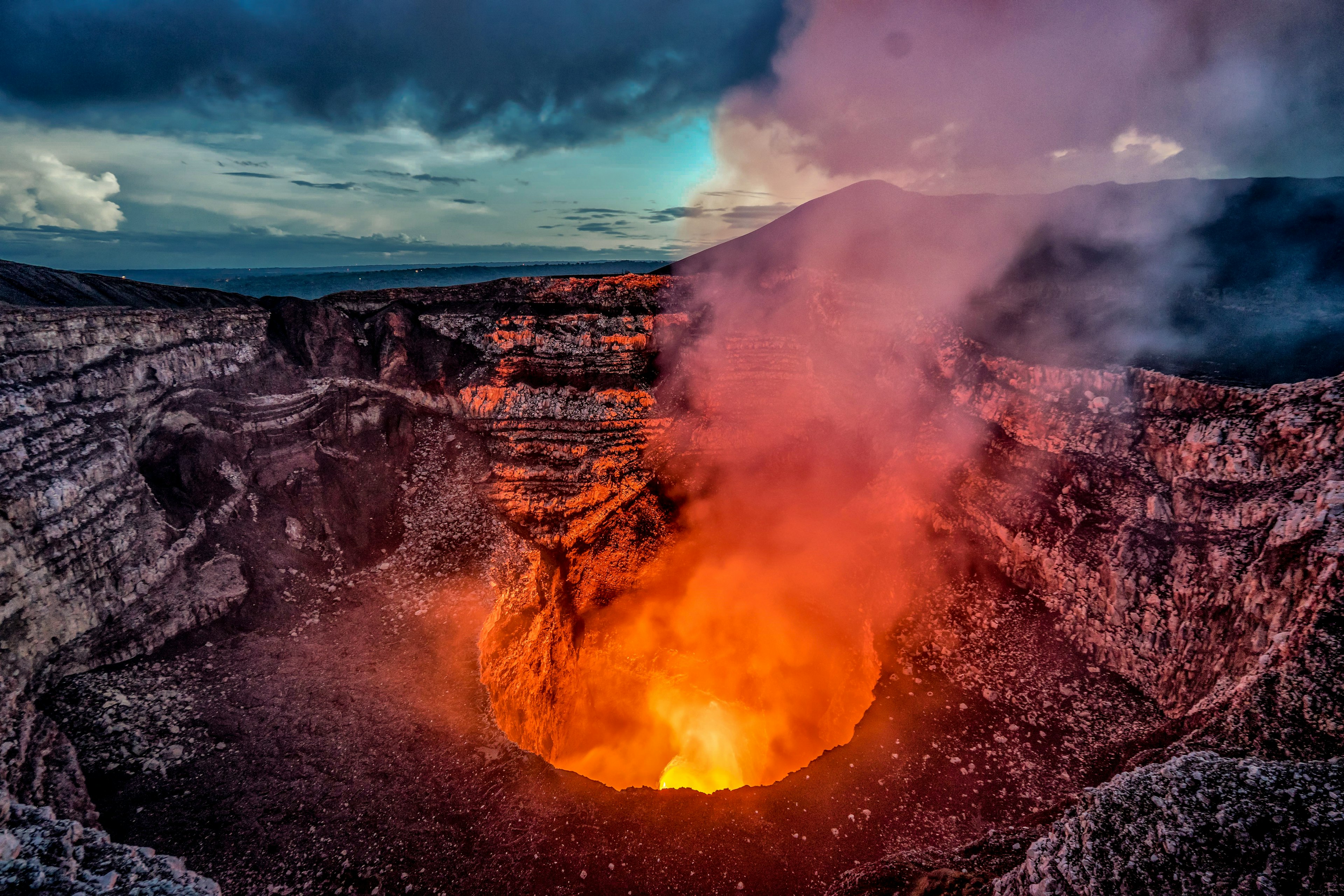 Volcano crater eruption with flowing lava and smoke.