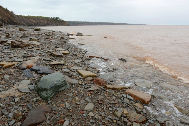 A jaggedy rocky coastline with waves lappin at the shore