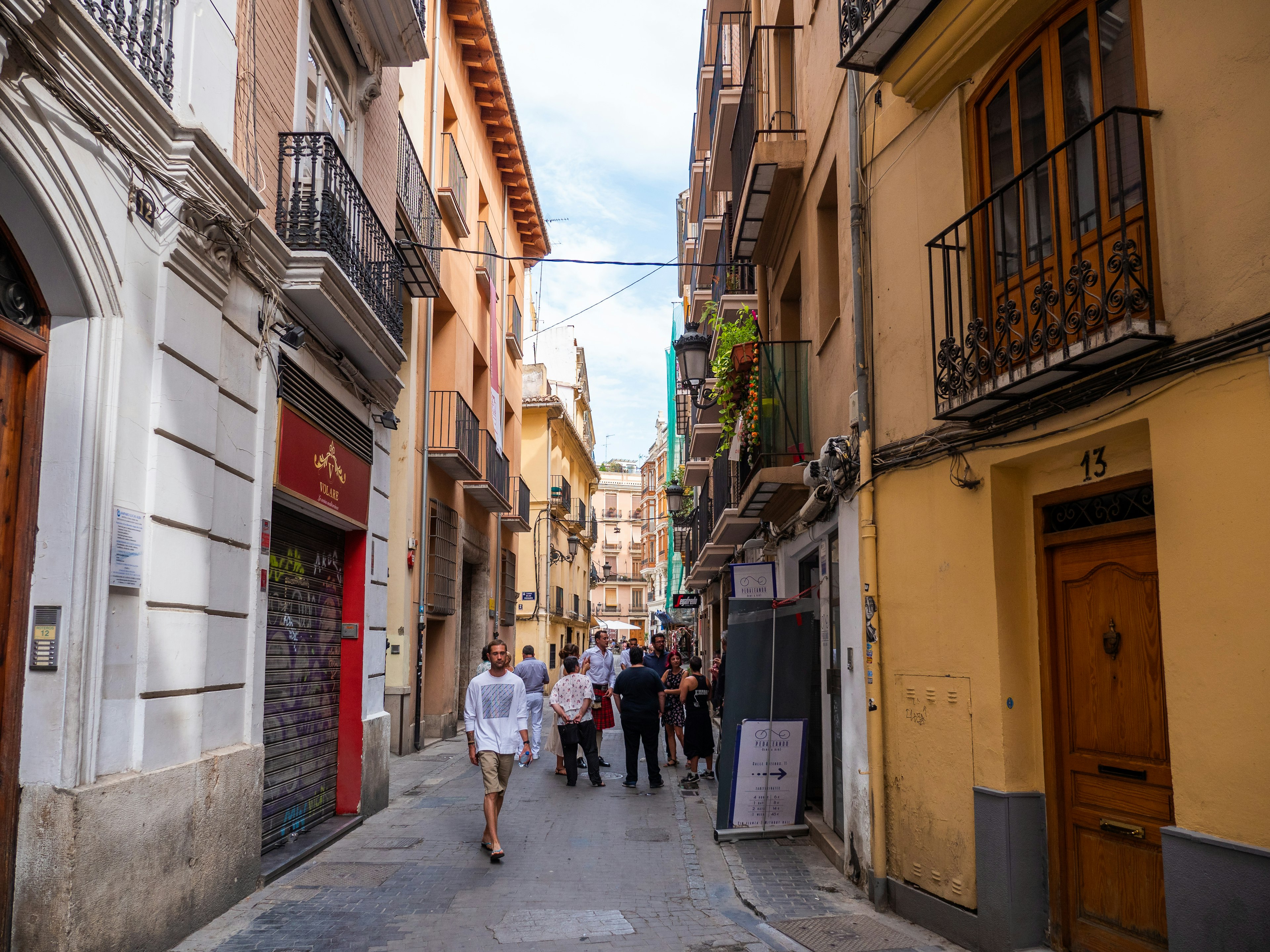 People wander down a narrow street in the Barrio del Carmen neighborhood, Valencia, Spain.