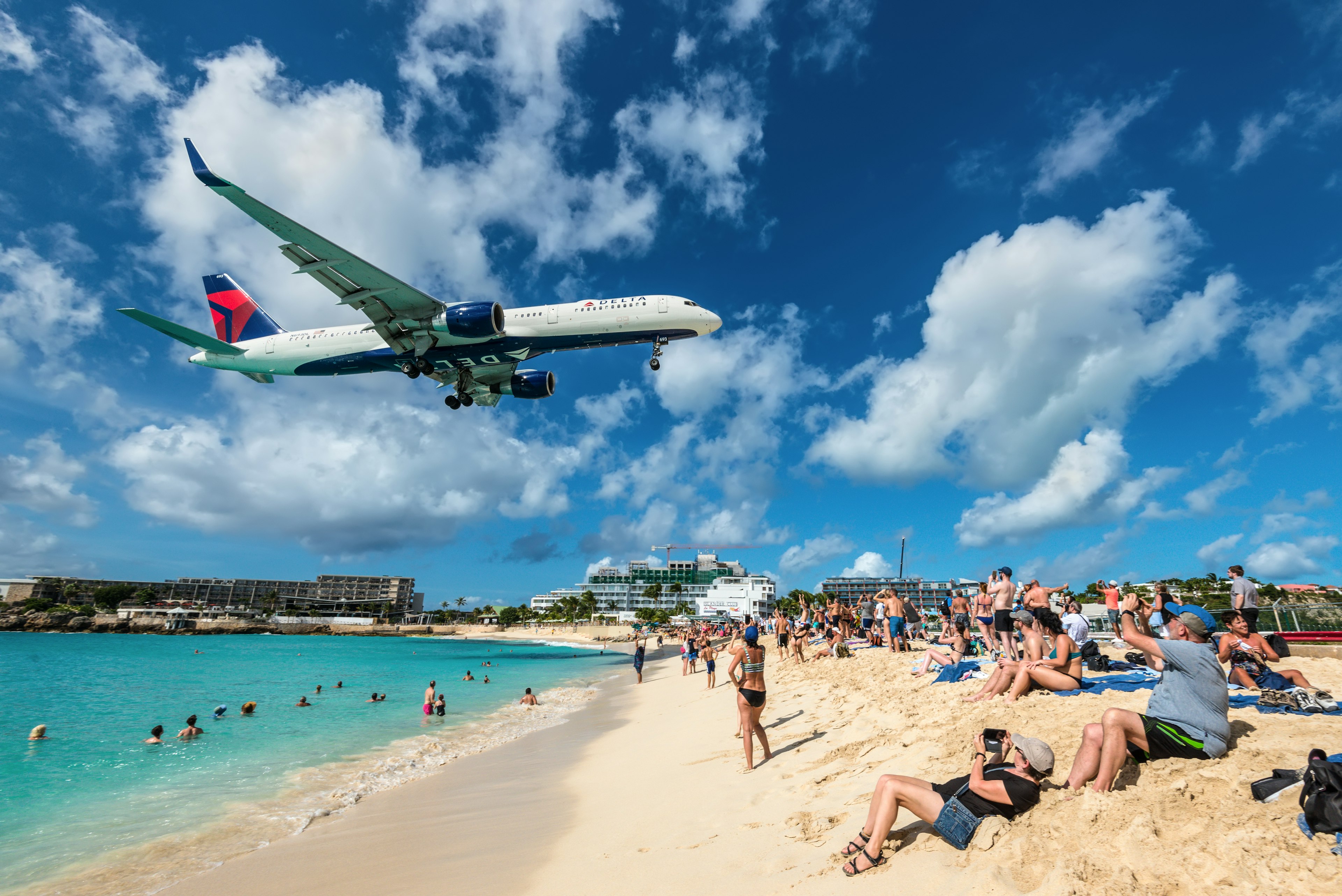 The commercial jet Delta Air Lines approaches Princess Juliana airport above onlooking spectators in Maho beach, Sint Maarten