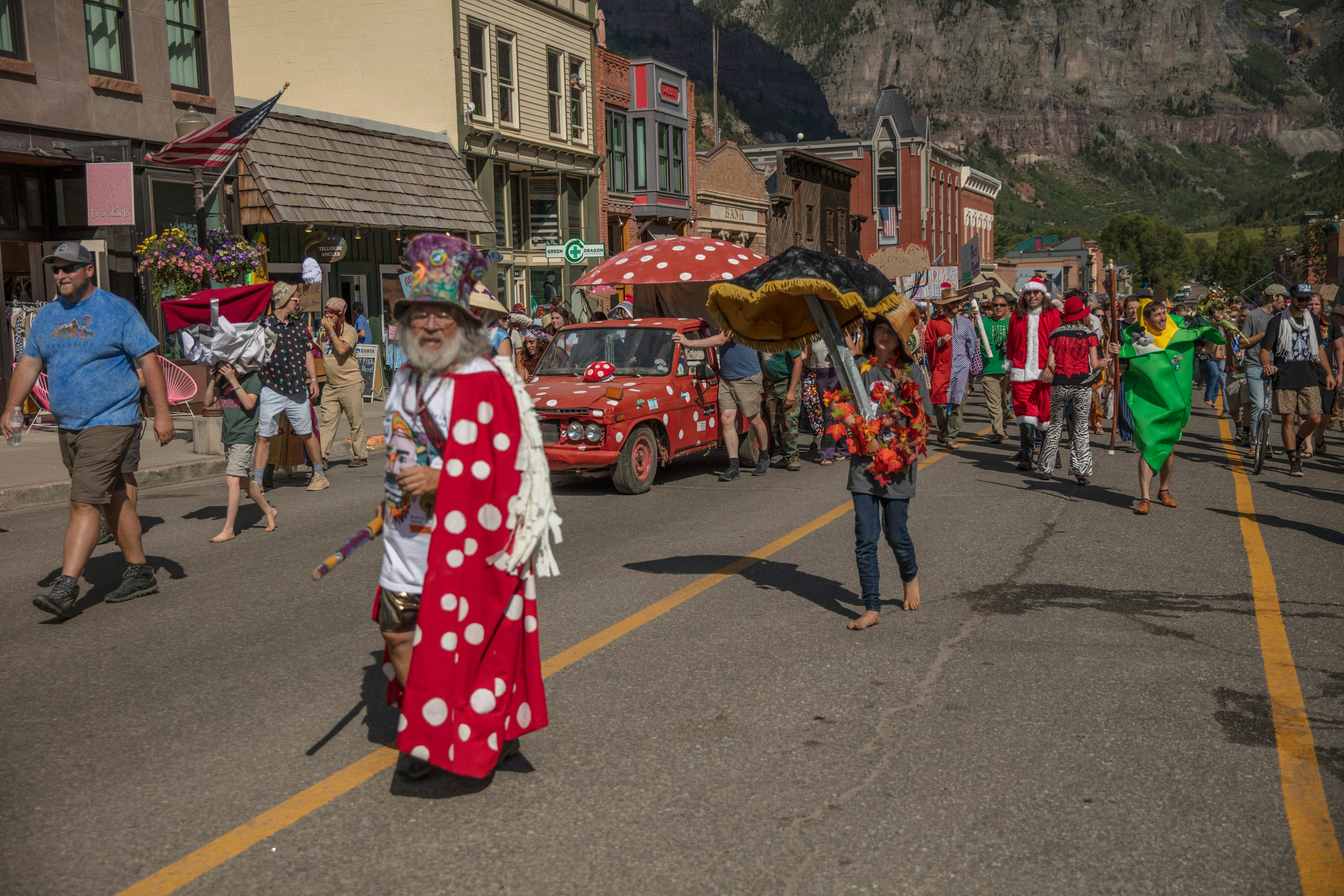 People in quirky costumes participate in a parade during the Telluride Mushroom Festival, Telluride, Colorado