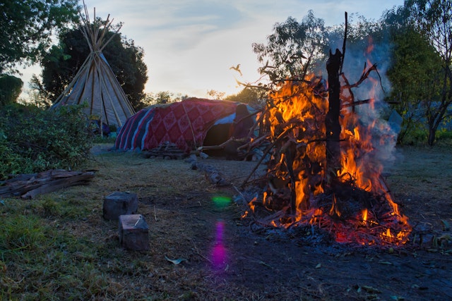 Temazcal or temascal, preparation for ritual in traditional native sweat lodge with hot stones and a fire in foreground in Mexico