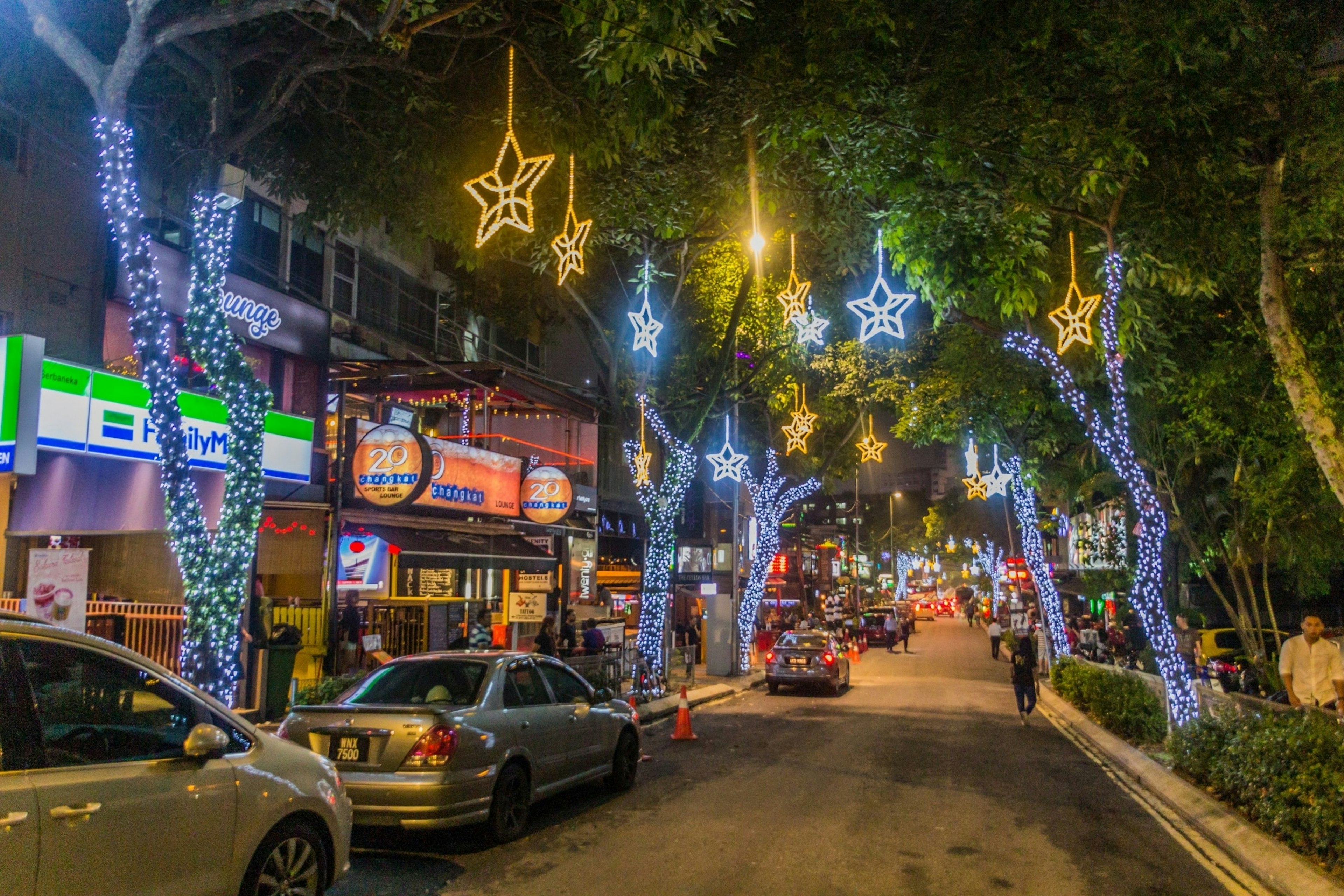 A street lined with bars lit up in neon at night