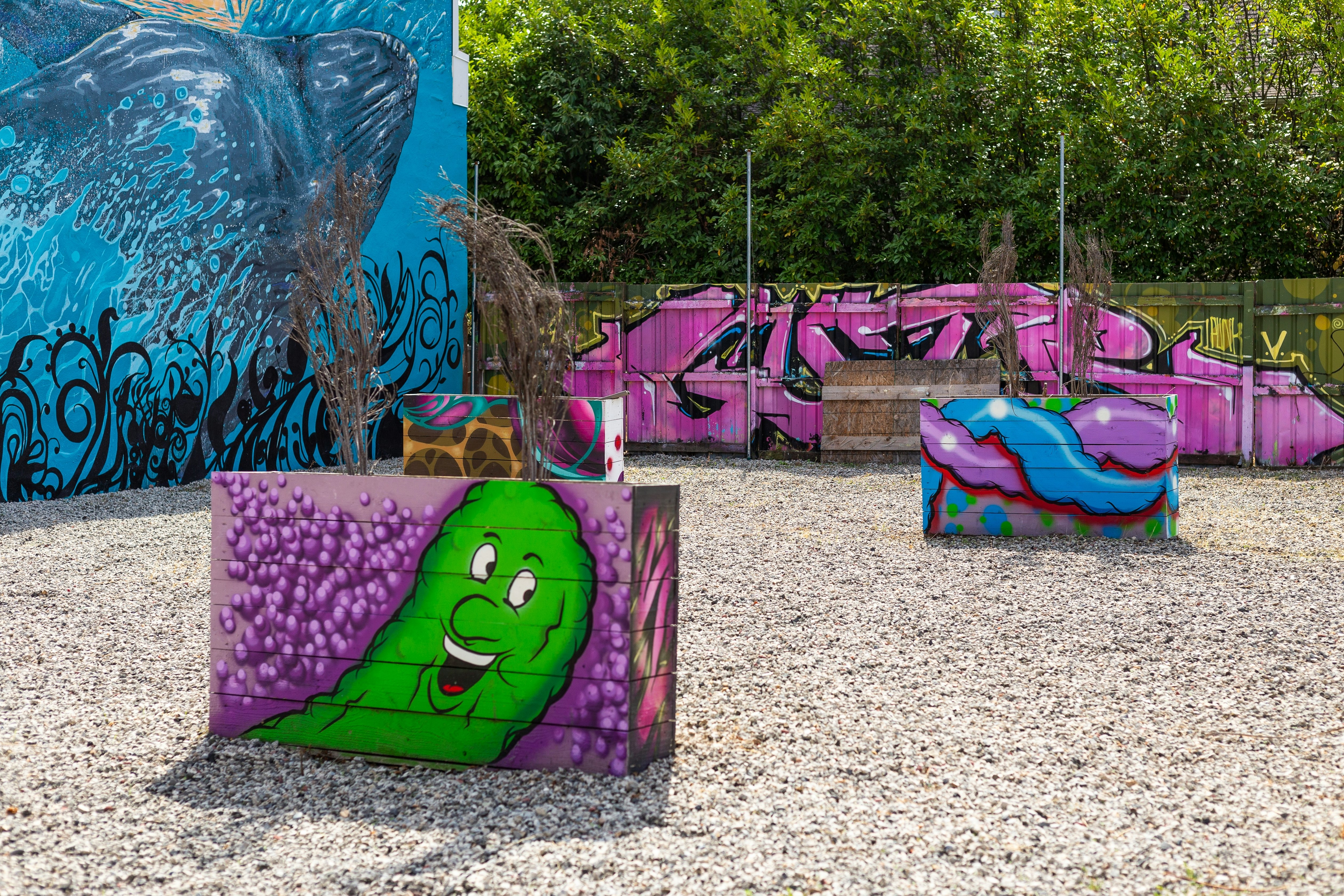 Interesting and colorful artwork painted on planters in a courtyard in the Alberta Arts District in Portland, Oregon, USA