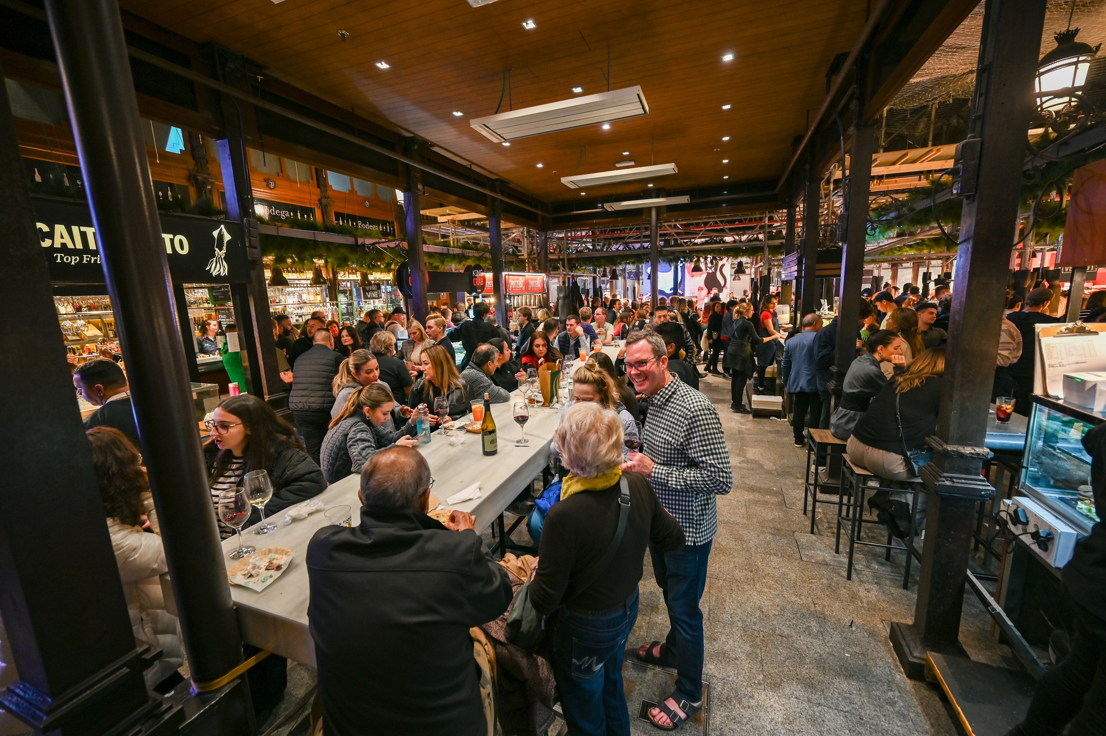 People dining at Mercado San Miguel in Madrid, Spain on tapas and pinchos : spanish appetizers at cocktail hour.