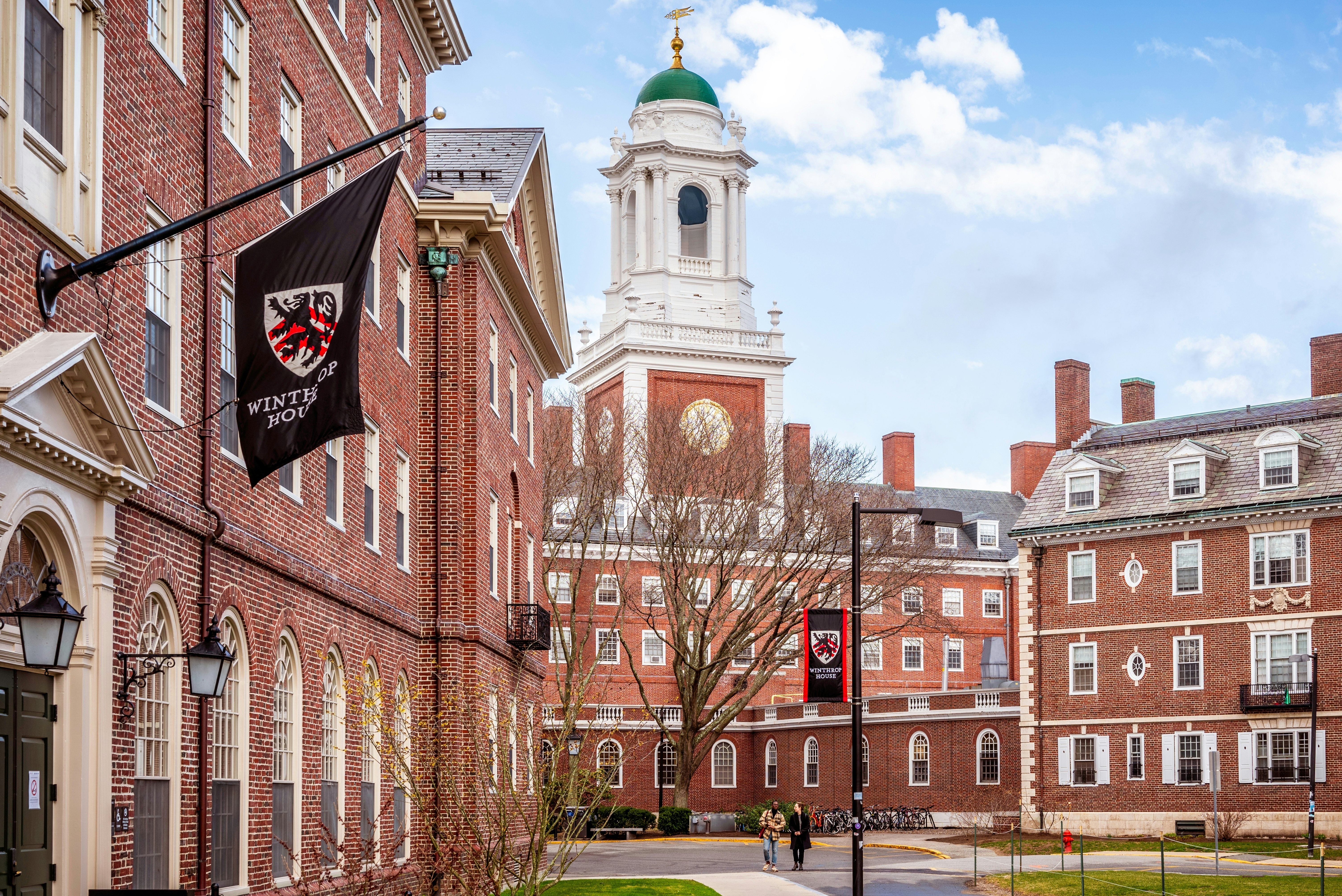 View of the architecture of the famous Harvard University in Cambridge, Massachusetts, USA showcasing it brick buildings with some students and locals passing by