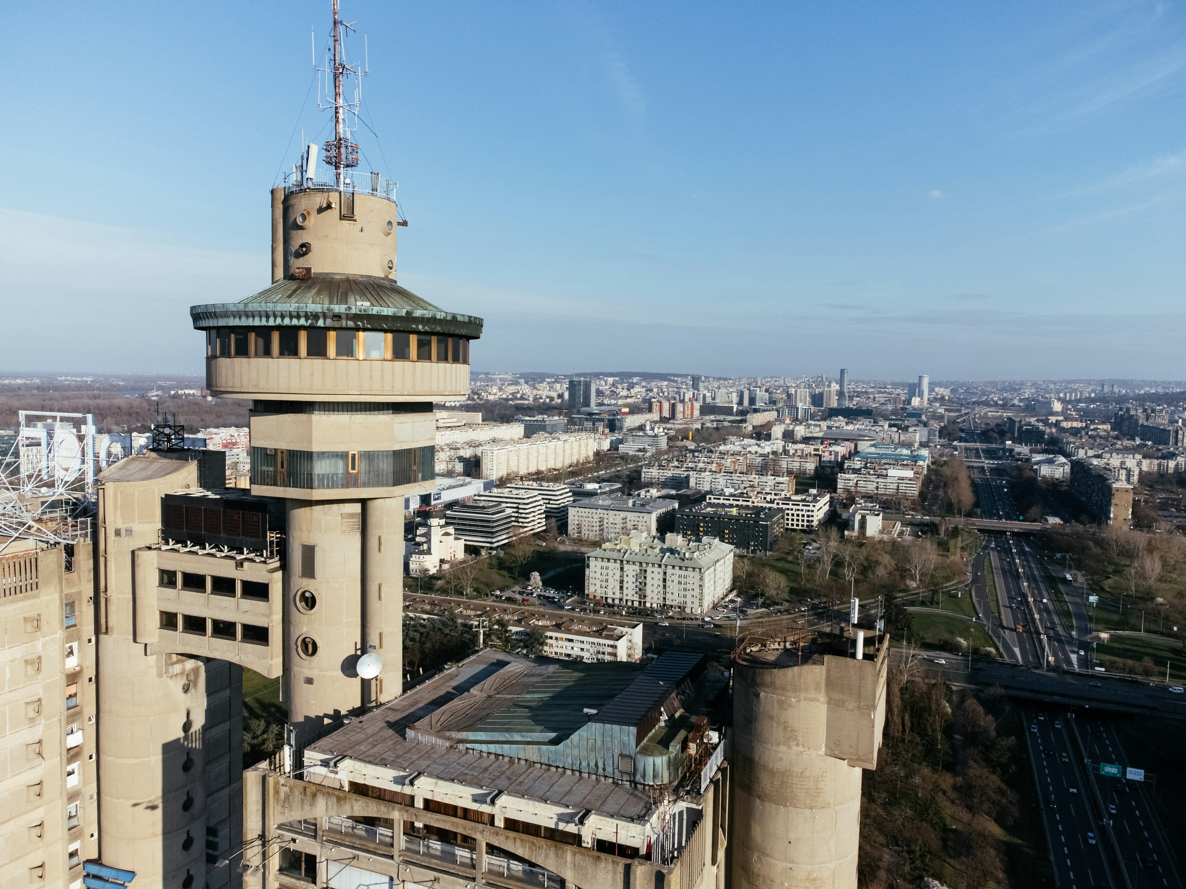 A huge brutalist tower with a panoramic deck offering views across the city