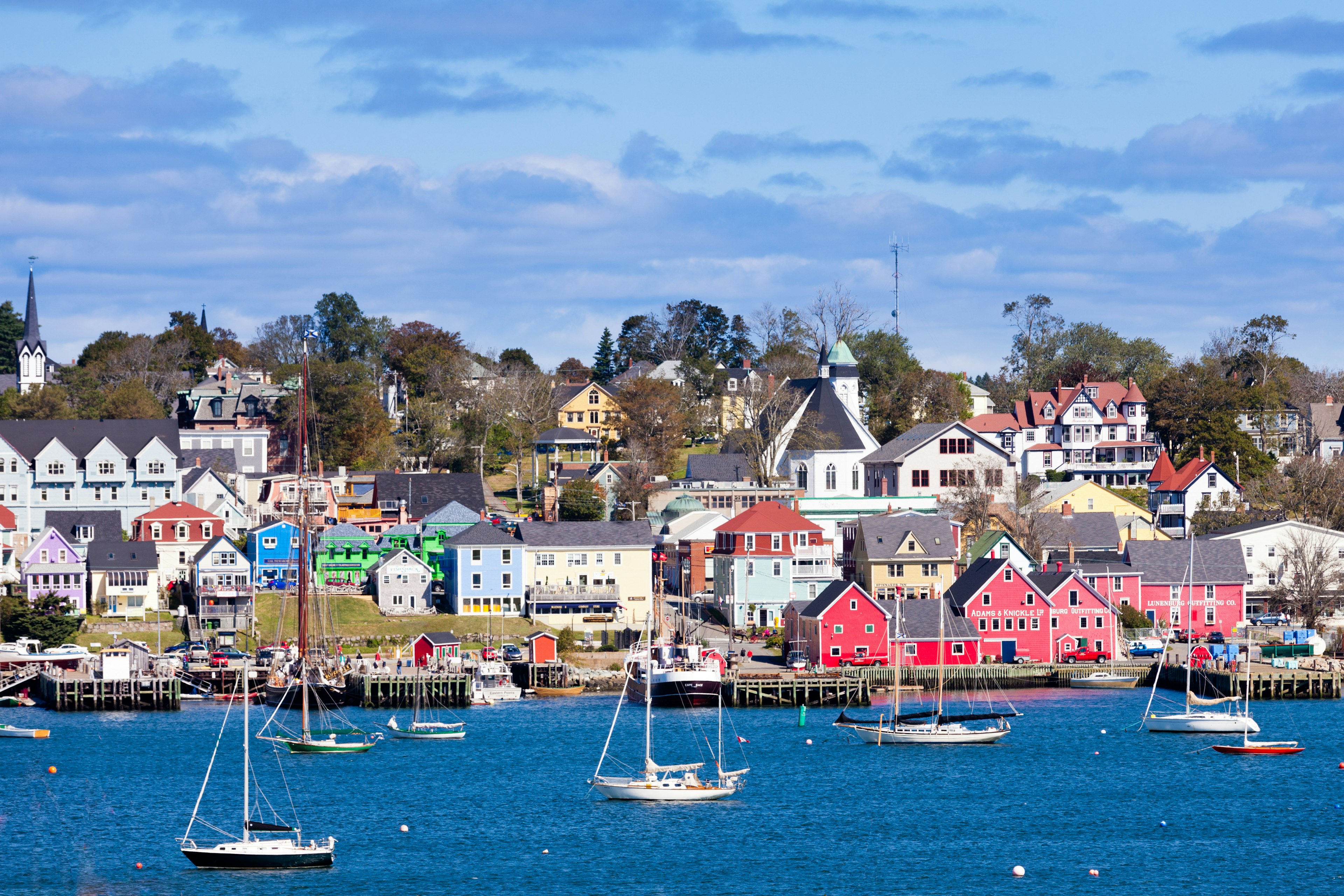 Wooden houses in bright colors line the front of a small fishing harbor