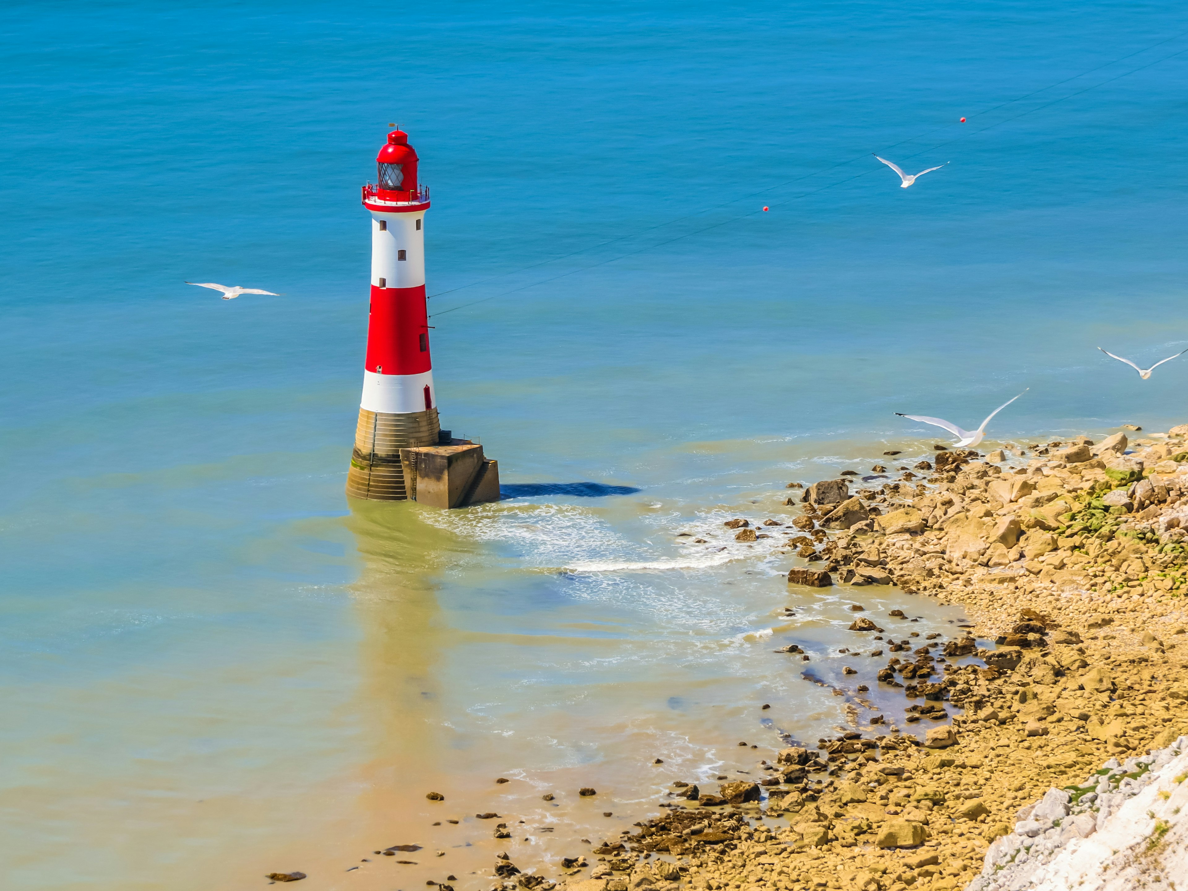 White chalk cliffs and aerial view of Lighthouse Beachy Head